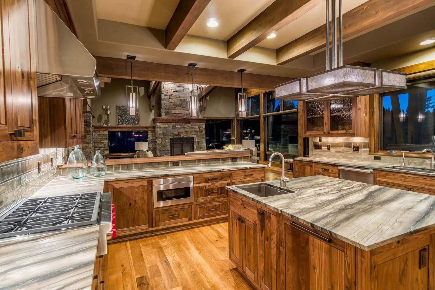 As experienced builders of luxury custom homes in Central Oregon, Pacwest Builders crafted this unique kitchen at Tetherow - Hawk Court. The space, with interiors by Kristy Yozamp, is defined by its beautiful wooden cabinets, a sleek marble counterto