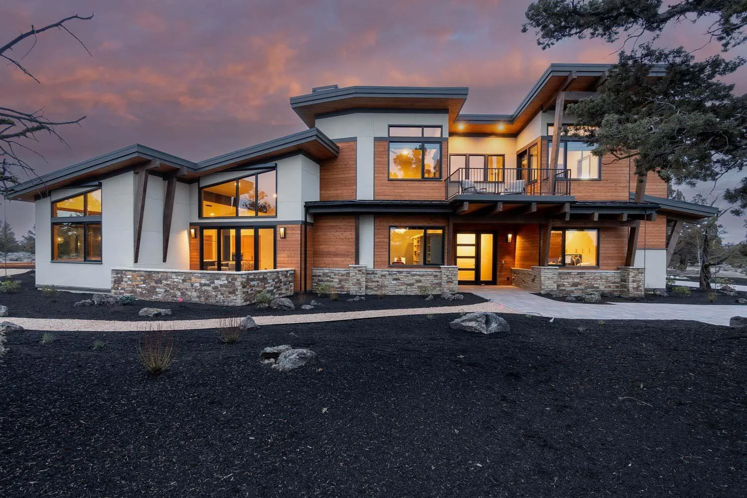 Illuminated from within with a warm, inviting glow at dusk, this stunning modern two-story house at Pronghorn - Switchback is a perfect example of design harmonized with its environment. The home's elegant wooden and stone exterior is a beautiful con