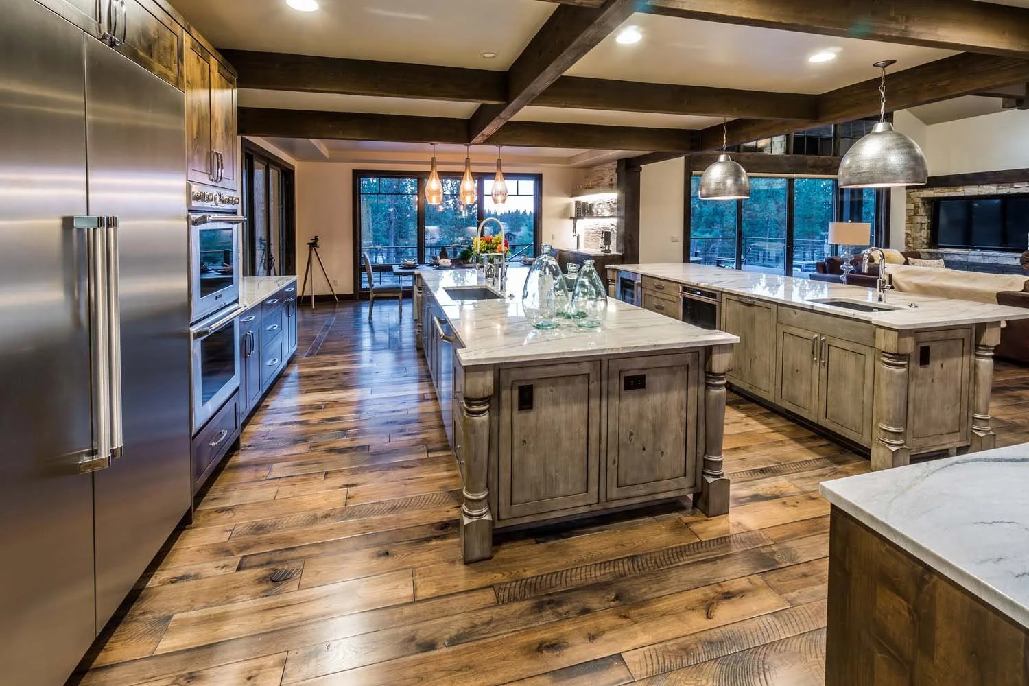 This stunning open-concept kitchen, a highlight of this Central Oregon home, is a testament to the masterful architecture and award-winning interior design. The room, designed by Spencer Williams, features a beautiful marble island, wooden cabinets,
