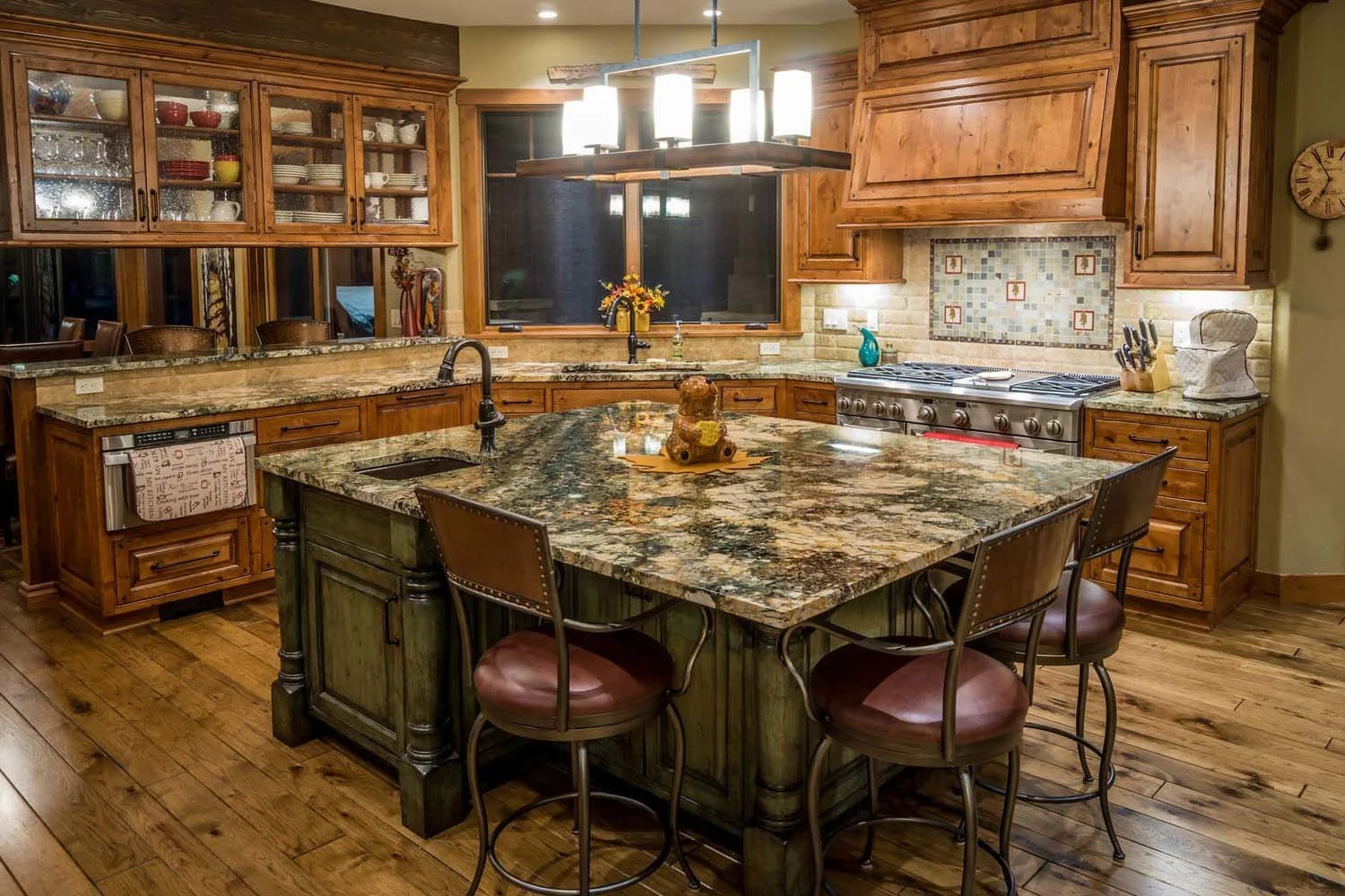 This mountain modern kitchen, a winner of the "Best Kitchen" and "Best of Show" awards, was designed by Spencer Williams with interiors by Kristy Yozamp. The spacious room features beautiful wooden cabinets, a large granite island with bar stools, an