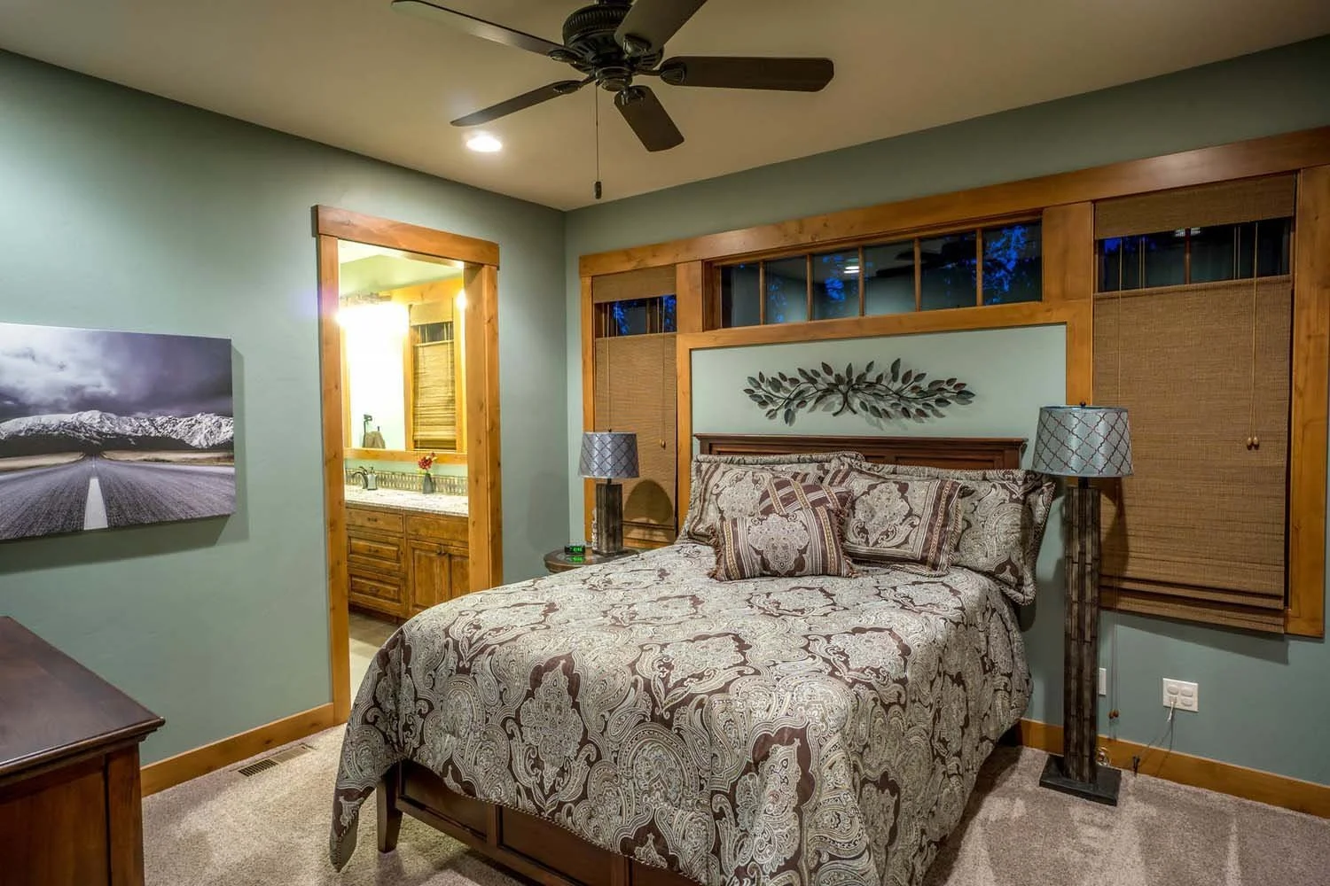 Designed by Spencer Williams with interiors by Kristy Yozamp, this cozy bedroom won "Best of Show" and "Best Interior Finish." The space features a beautiful wooden bed, a built-in window seat, and warm wood paneling on the ceiling, creating a perfec