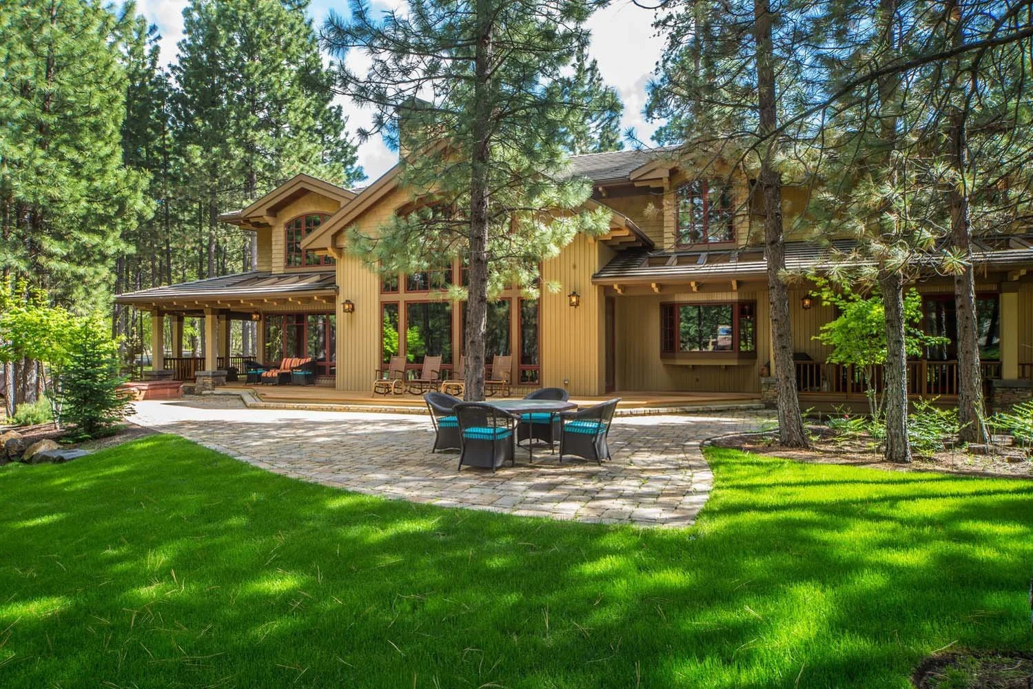 This stunning residence in Black Butte Ranch - Foin Follette showcases a seamless blend of architecture and nature. The large house, built by Pacwest Builders, features a beautiful wooden exterior and large windows that provide a view of the surround