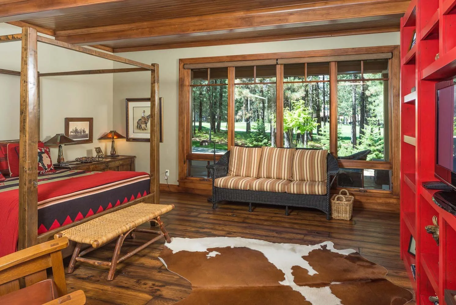This stunning bedroom, a highlight of this Central Oregon retreat, is a testament to the masterful architecture design by Steve Van Sant. The space, with its wooden four-poster bed, rustic decor, and a cowhide rug, creates a warm and inviting atmosph