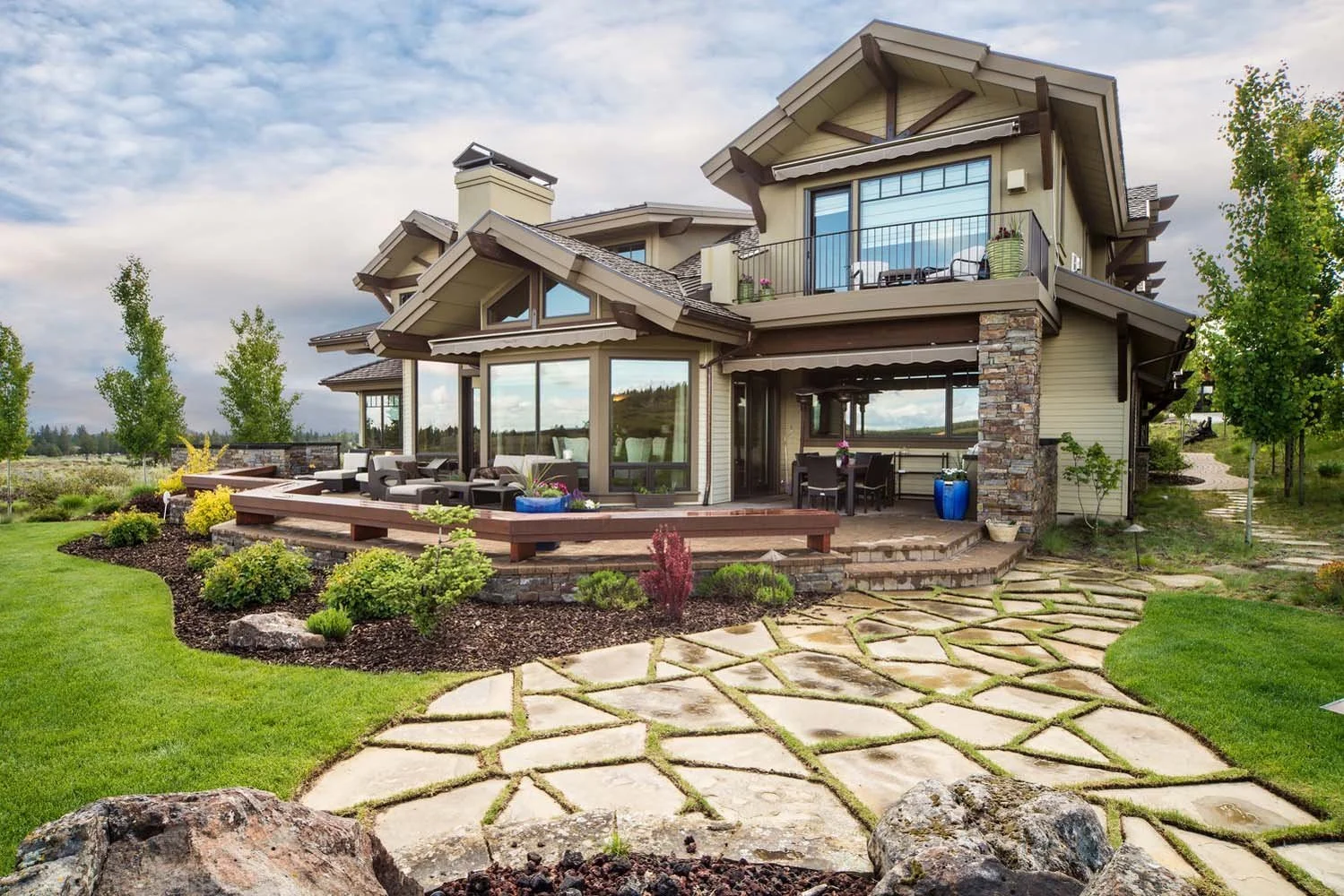 This luxury custom home in Tetherow - Skene Trail, designed by Steve Van Sant, is a masterpiece of modern architecture. The two-story house features a large patio with glass doors, perfectly situated in a beautifully landscaped yard. The geometric st