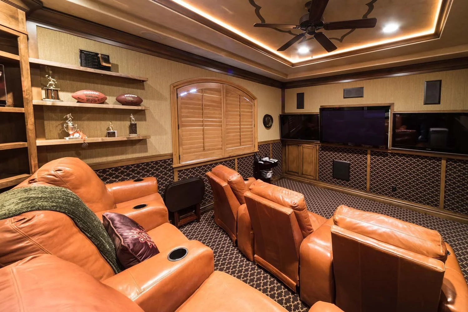 This cozy home theater room, a highlight of this luxury custom home in Tetherow - Skene Trail, is a showcase of masterful interior design by Kristy Yozamp. The space, with its comfortable leather recliner seats and two large flat-screen TVs, is desig