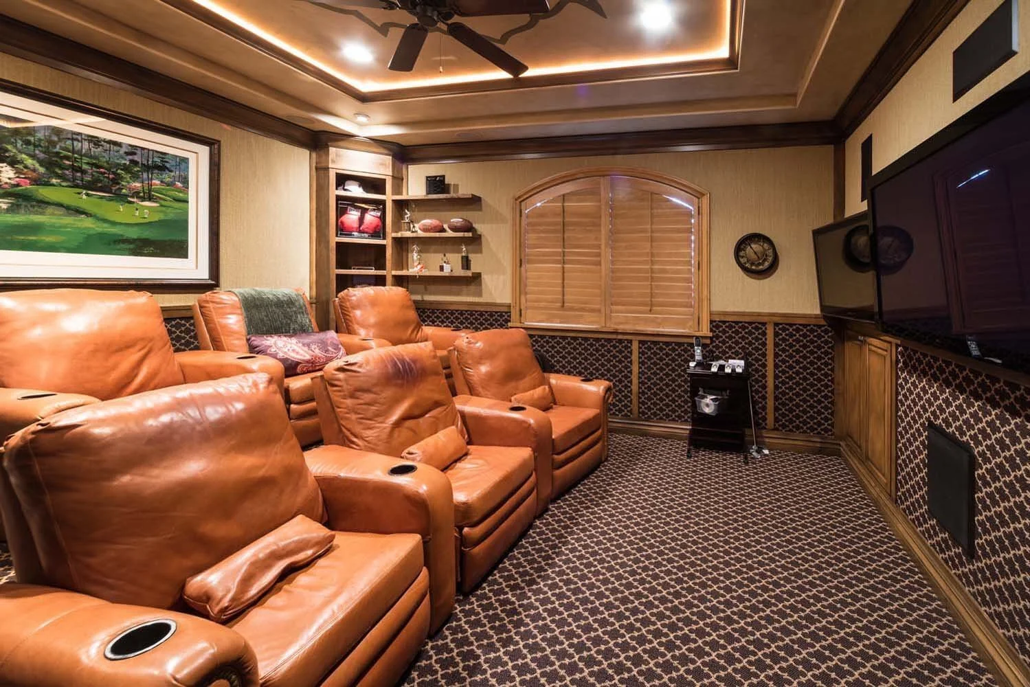 This cozy home theater room in Tetherow - Skene Trail, a luxury custom home, is a showcase of masterful interior design by Kristy Yozamp. The space, with its six leather recliner chairs and a large flat-screen TV, is designed for ultimate comfort and