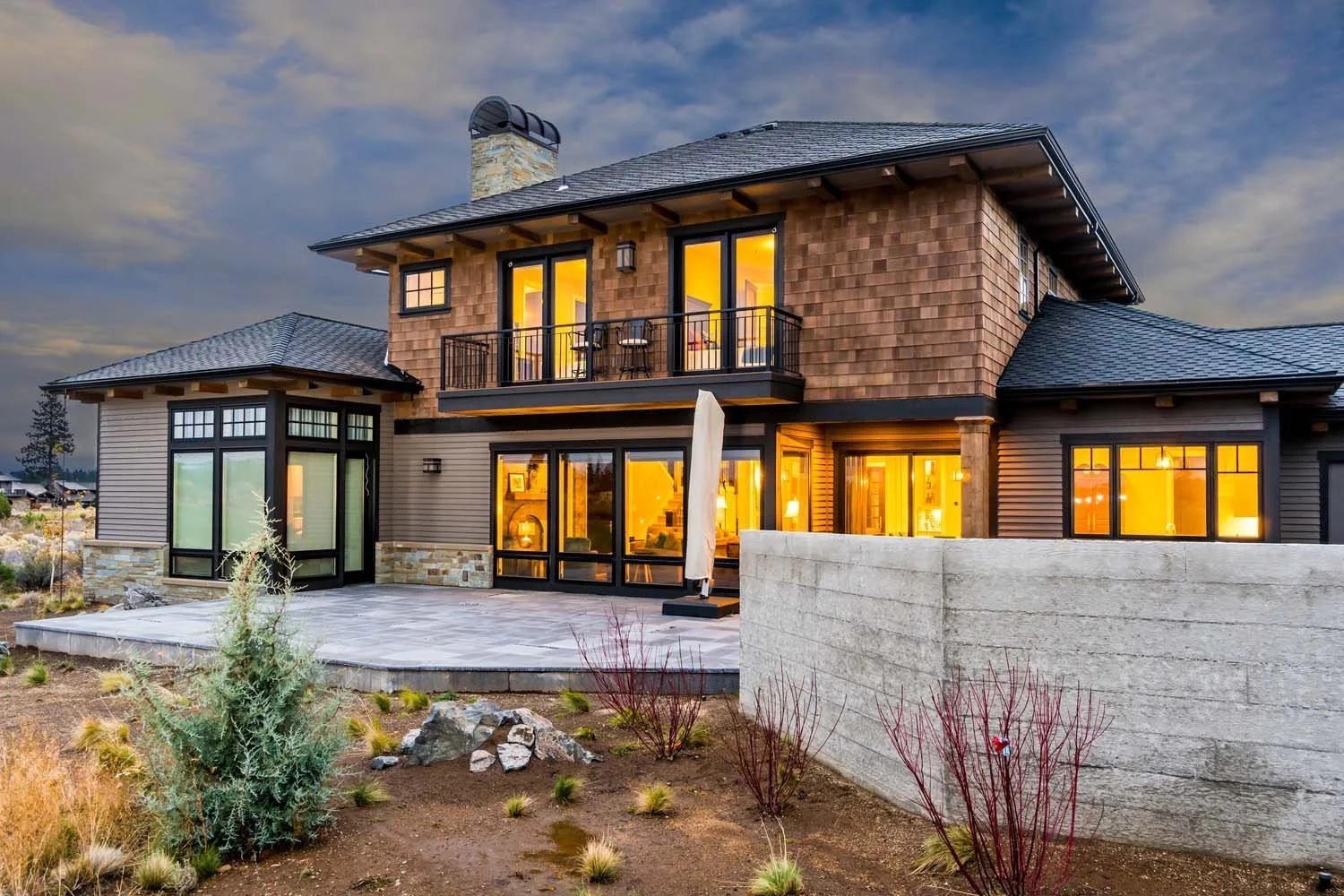 This stunning modern residence in Tetherow - Skene Trail, designed by Steve Van Sant, is a testament to the high-quality craftsmanship of Pacwest Builders. The home features a mixture of wood, stone, and siding, with large windows and a balcony, beau