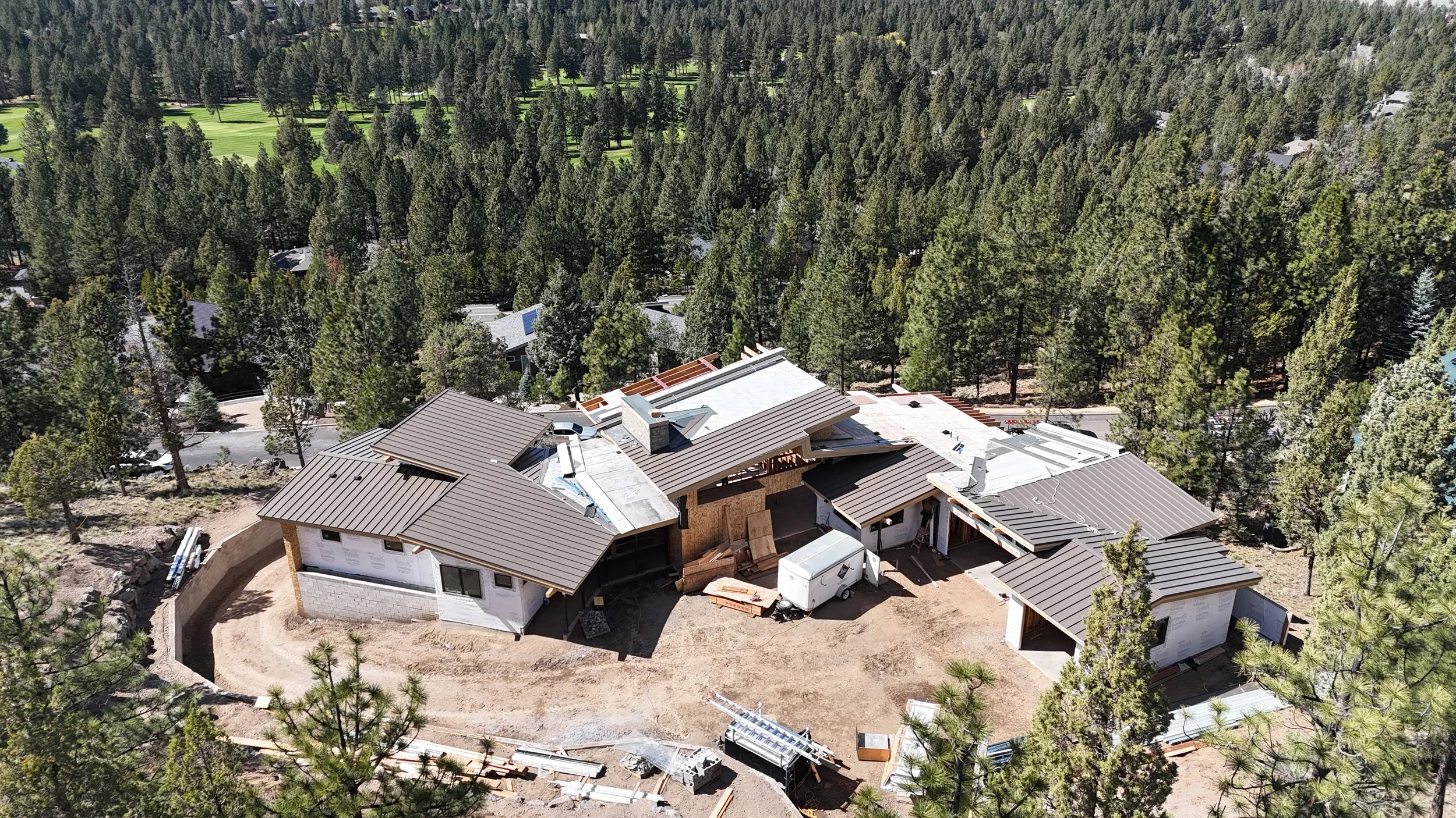 Aerial drone view of a custom home under construction in Awbrey Butte, designed by Spencer Williams and built by Pacwest Builders, featuring an East-facing entry courtyard.