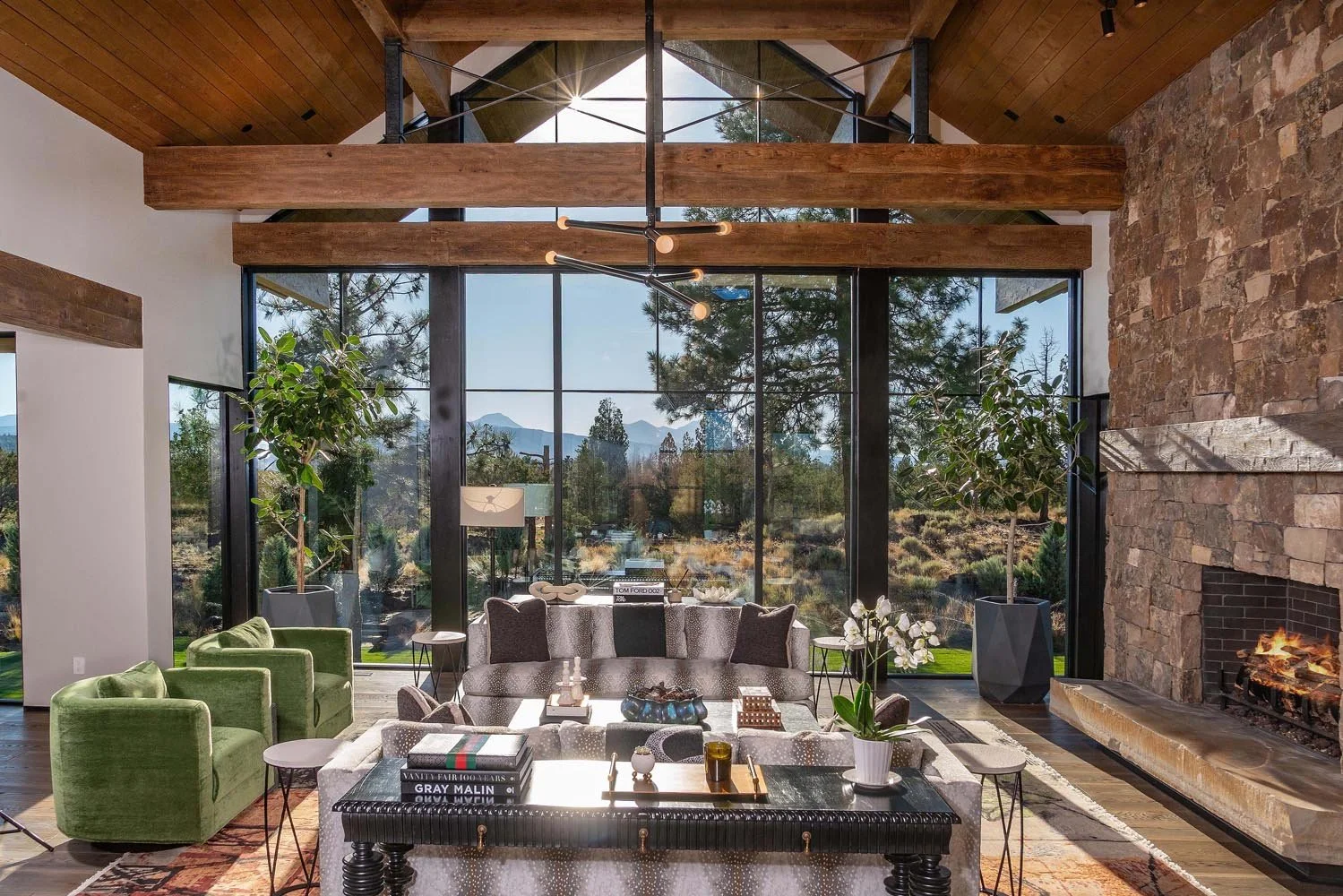 The majestic living room at Pacific Cascade Heights embodies mountain modern luxury, a collaboration between Pacwest Builders and the interior design by Kate Darden. Expansive glass windows by Fleetwood Windows and Doors perfectly frame breathtaking