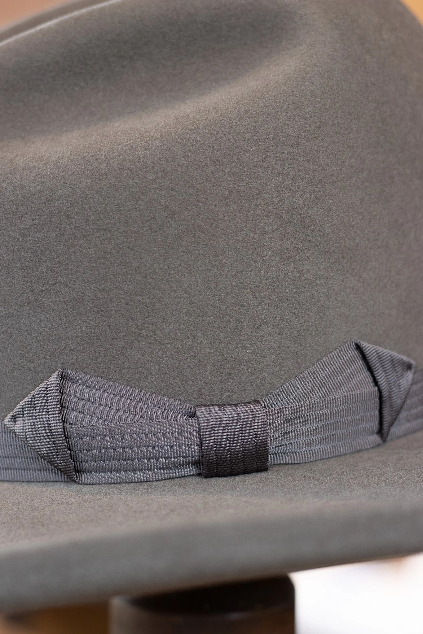 Close-up view of a gray upholstered chair with a decorative gray bow strap.