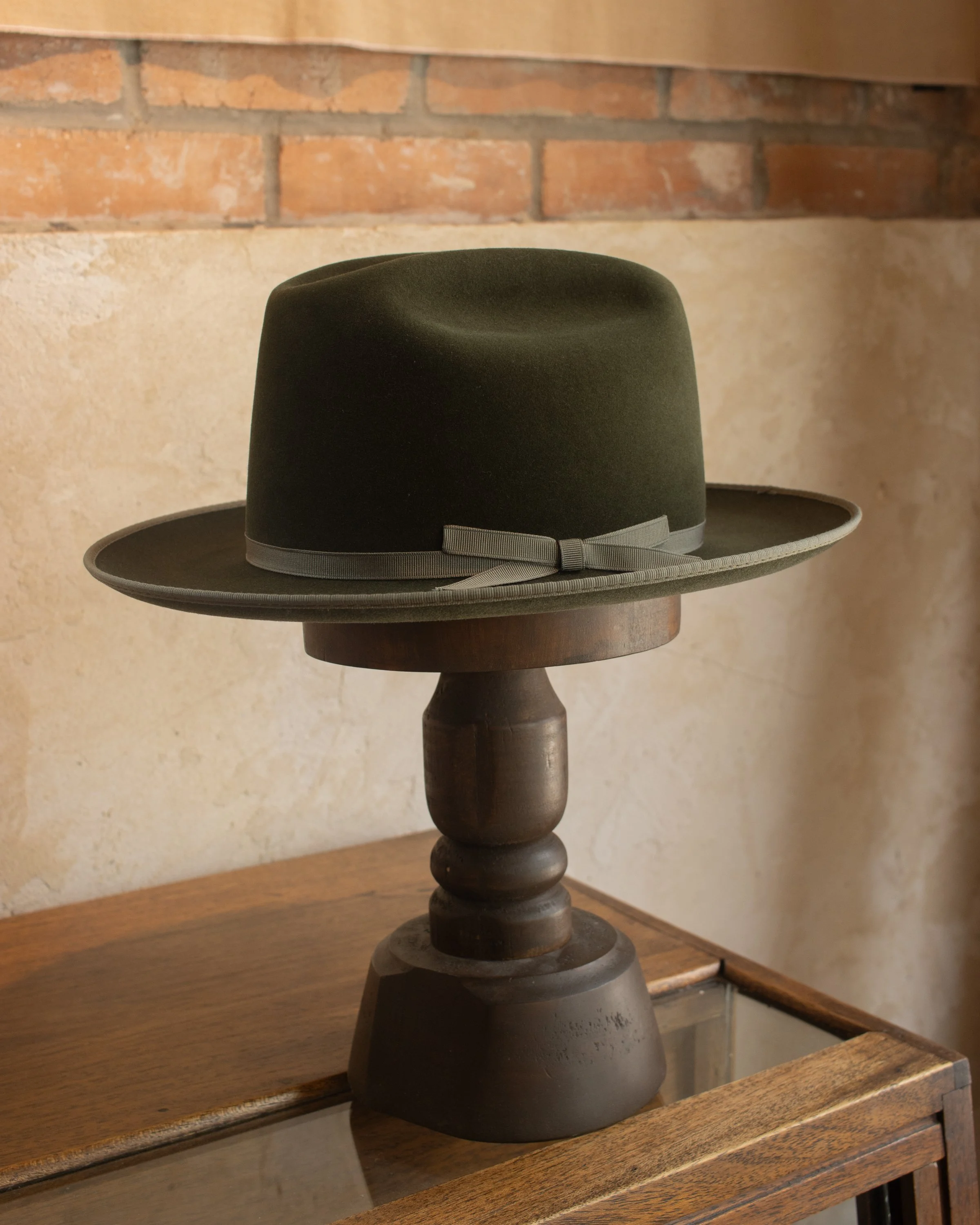 Custom made Open Road hat in a green moss color with monotone grosgrain ribbon hand sewn leather sweatband and hand bound brim. Made in Texas based local hat shop Rhode and Sons. 