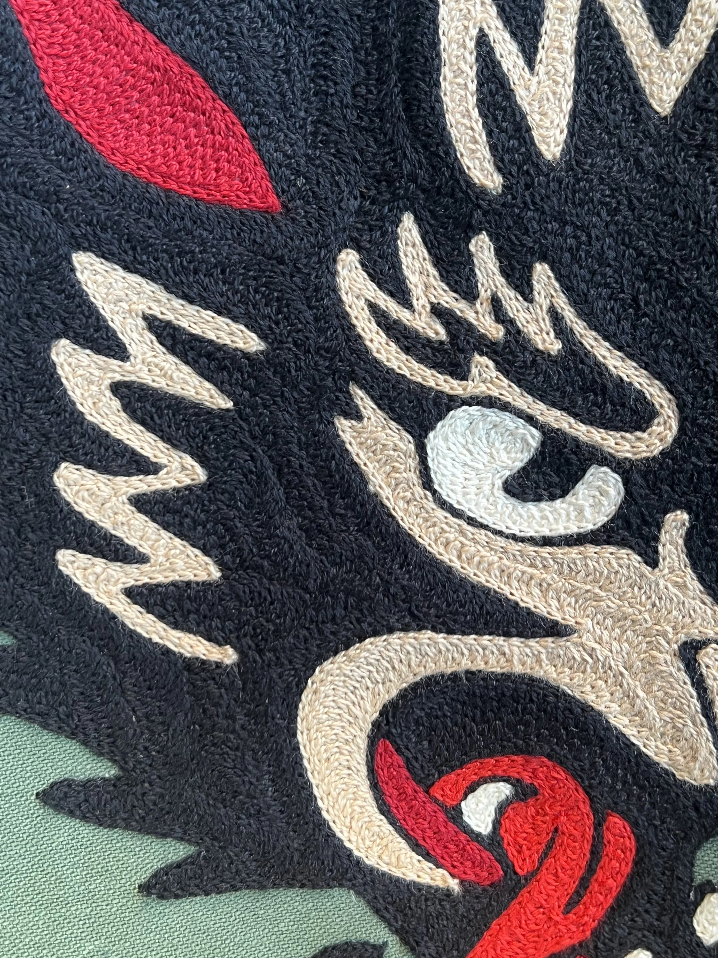 Close-up of a chainstitch embroidery using a vintage hand cranked chainstitch embroidery machine made in a local small business embroidery shop in Dallas Texas. Custom hand drawn design on a vintage military style Imogene and Willie green army jacket