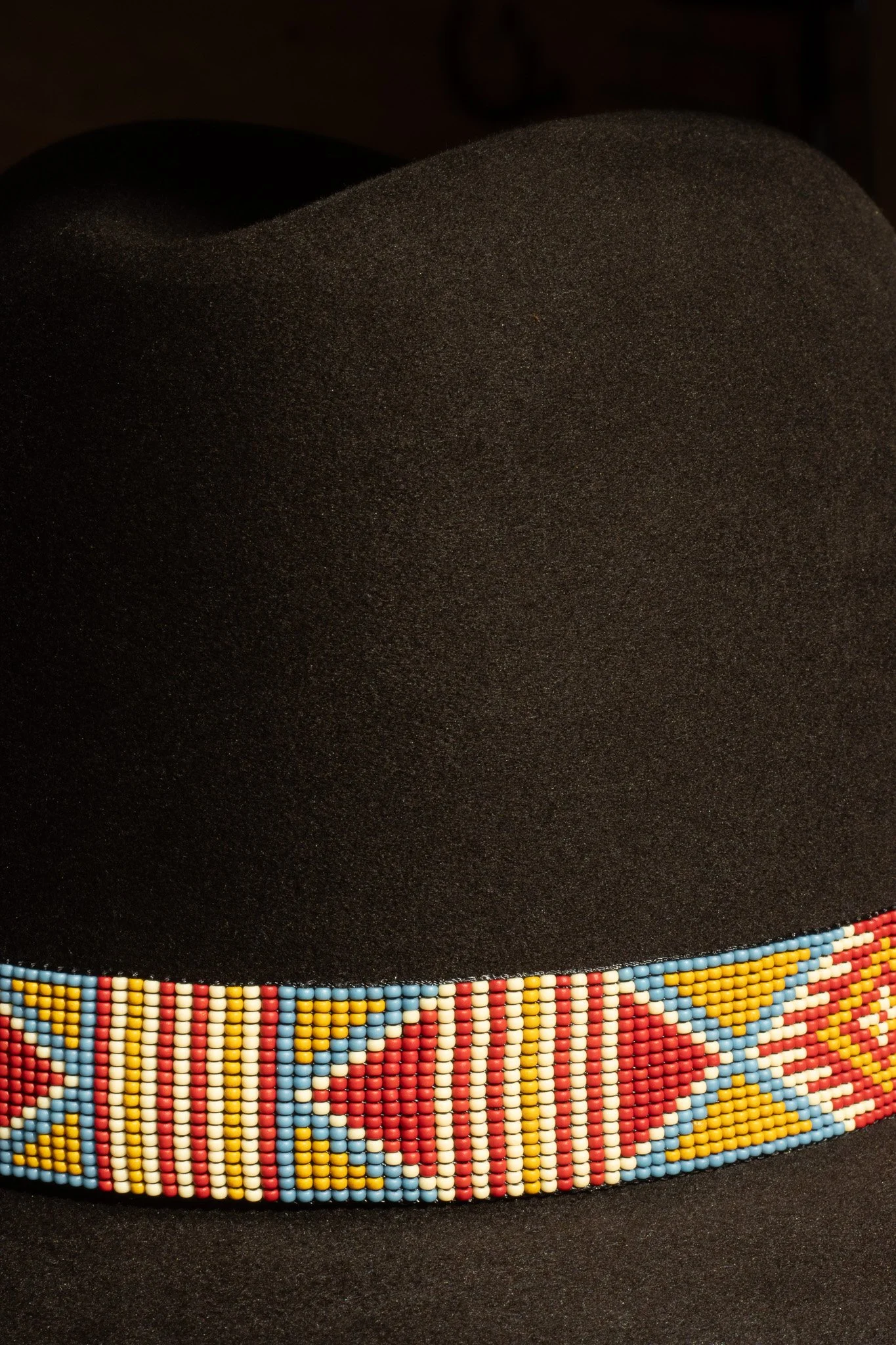 Dark brown chocolate felt pure beaver handcrafted hat with a native style beaded band in a Santa Fe inspired color palette.