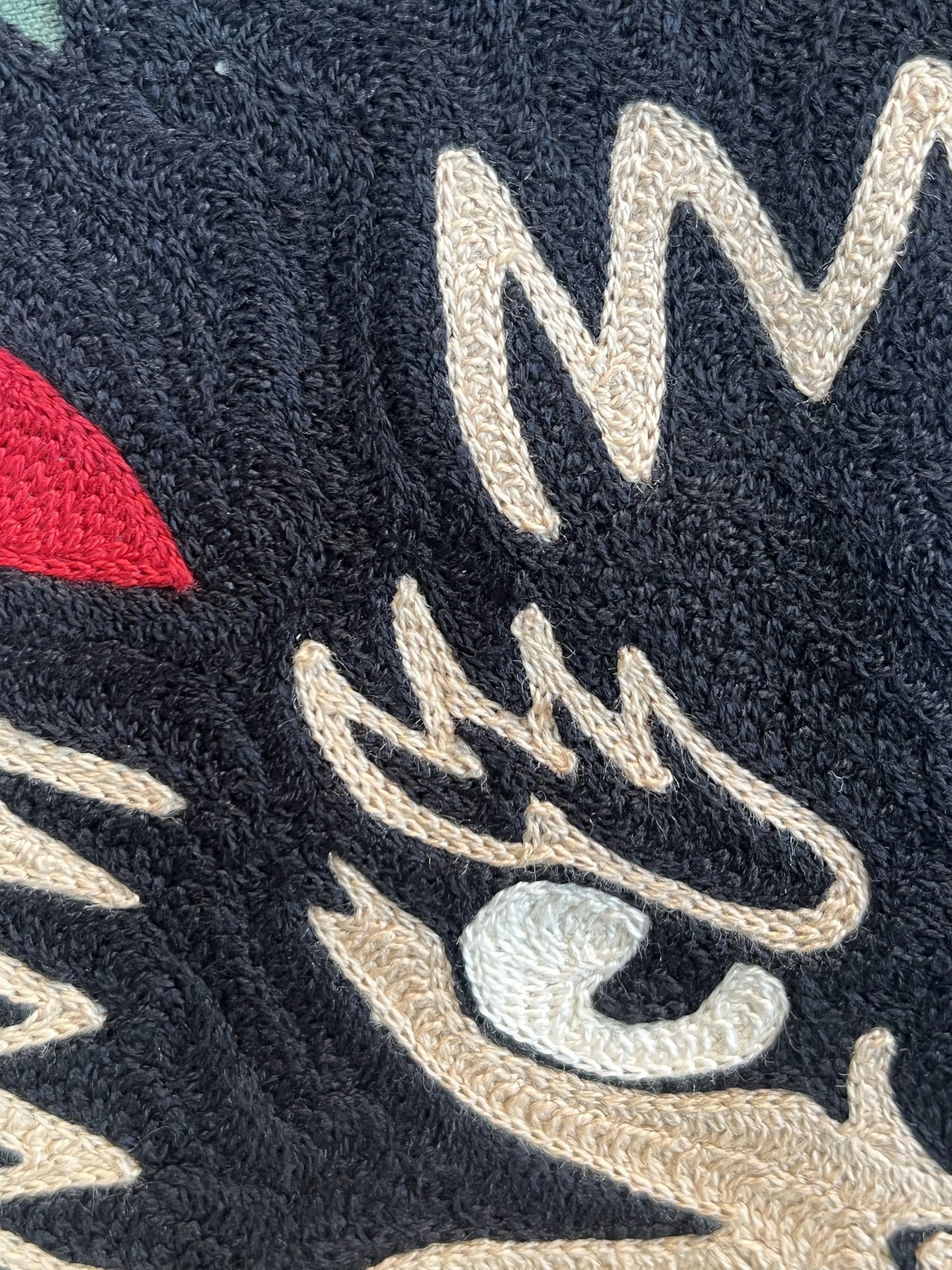 Close-up chainstitch embroidered using a vintage hand cranked chainstitch embroidery machine made in a local small business embroidery shop in Dallas Texas. Custom hand drawn design on a vintage military style Imogene and Willie green army jacket