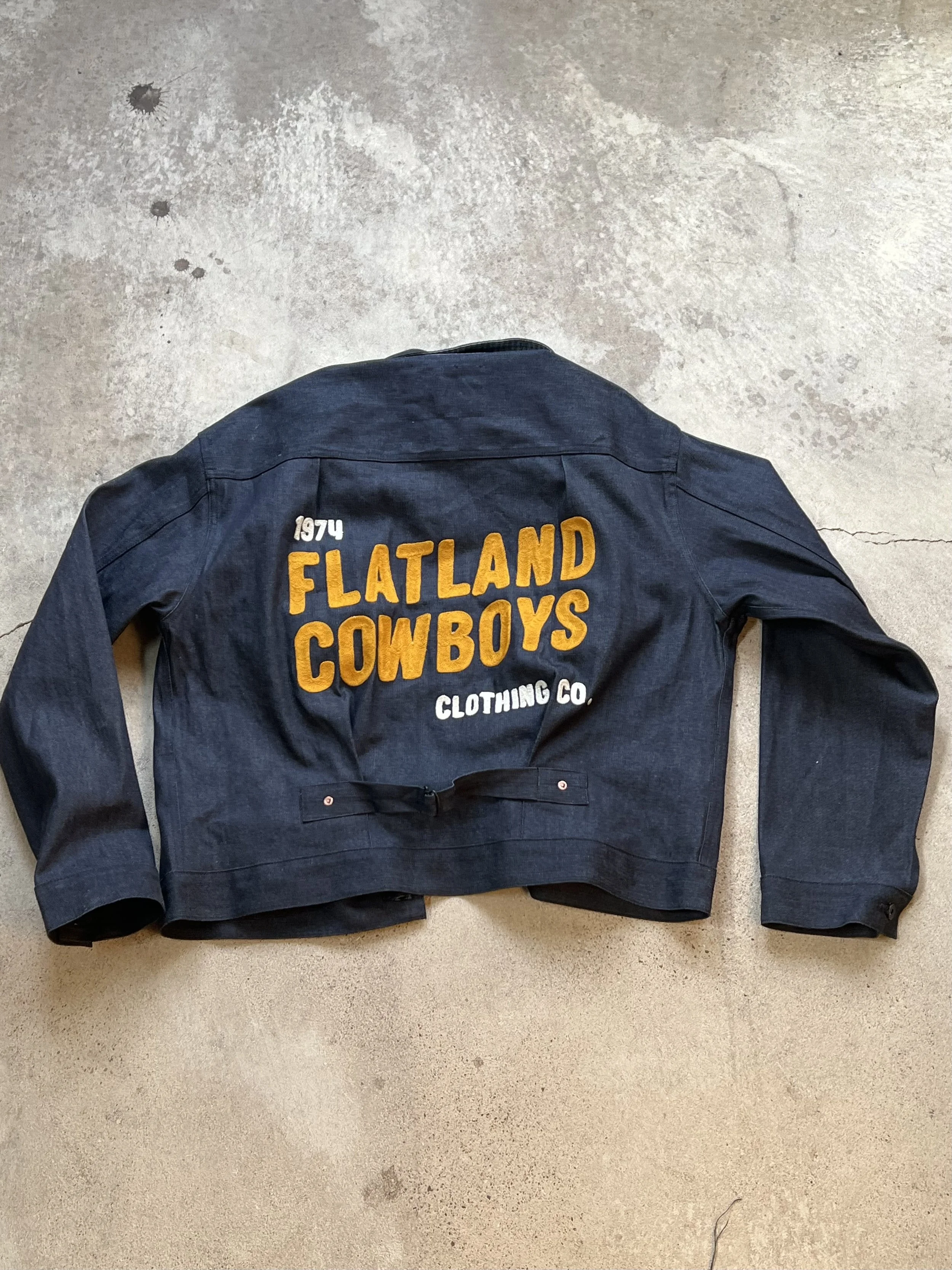 Vintage style selvedge denim Mister Freedom jacket featuring custom chainstitch embroidery on the bag as a traditional marketing piece for a small local business, Made in Dallas Texas in a store that offers chainstitch embroidery for hire. 