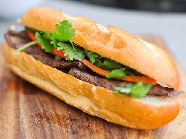 Beef sandwich with fresh herbs and vegetables on a baguette