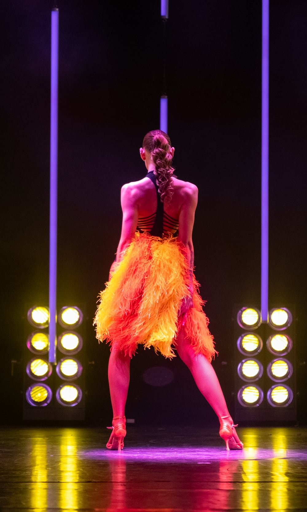 Kvinne i et danseshow med ryggen til på en scene