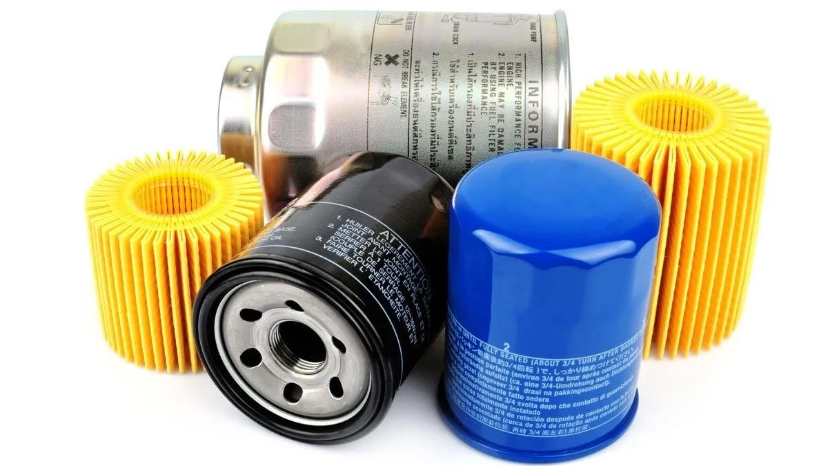 Automobile oil filter canister, black oil filter, blue oil filter, and two yellow filter cartridges on white background.