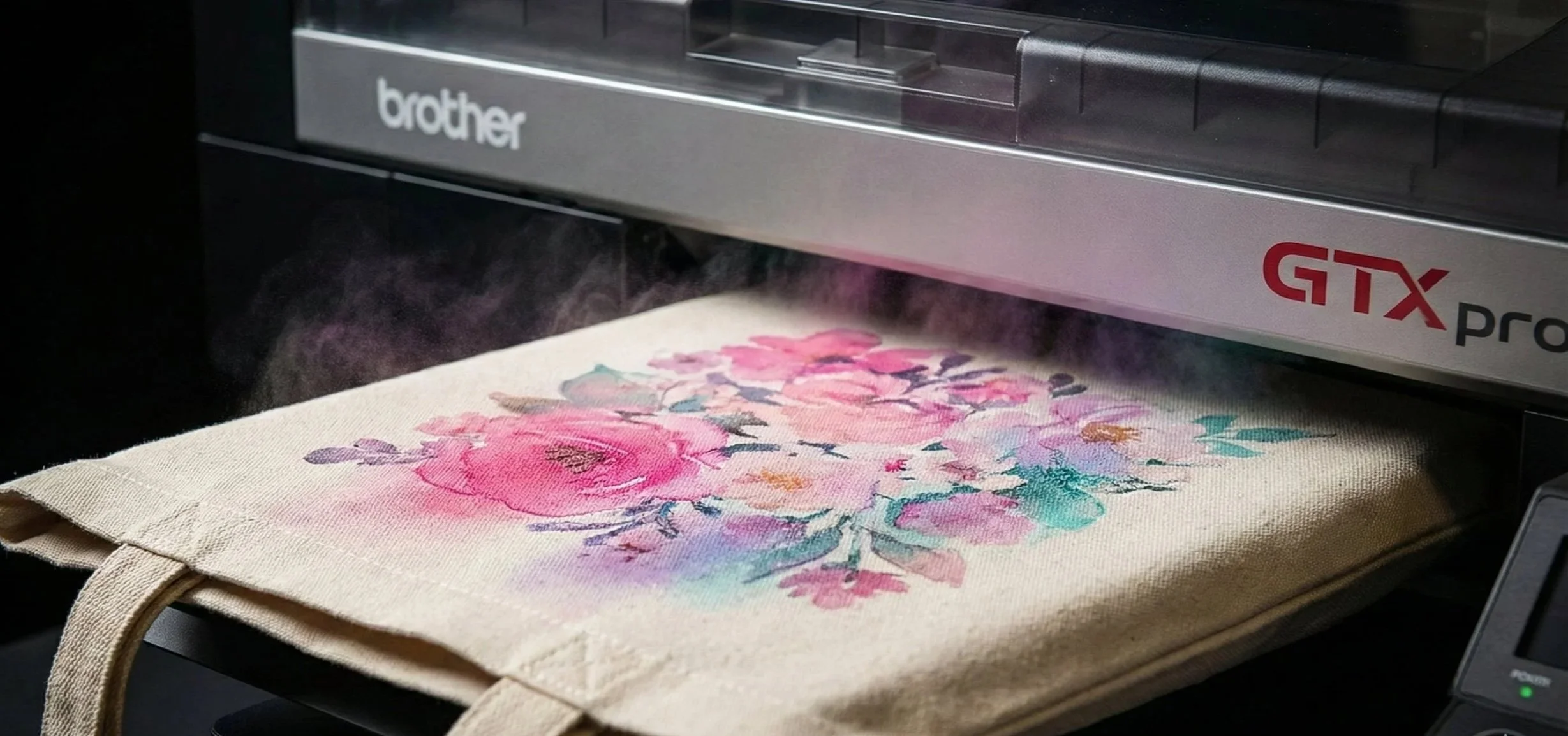 Cận cảnh máy in Brother GTXpro đang in hình hoa màu nước lên túi canvas với công nghệ in phun kỹ thuật số sắc nét.