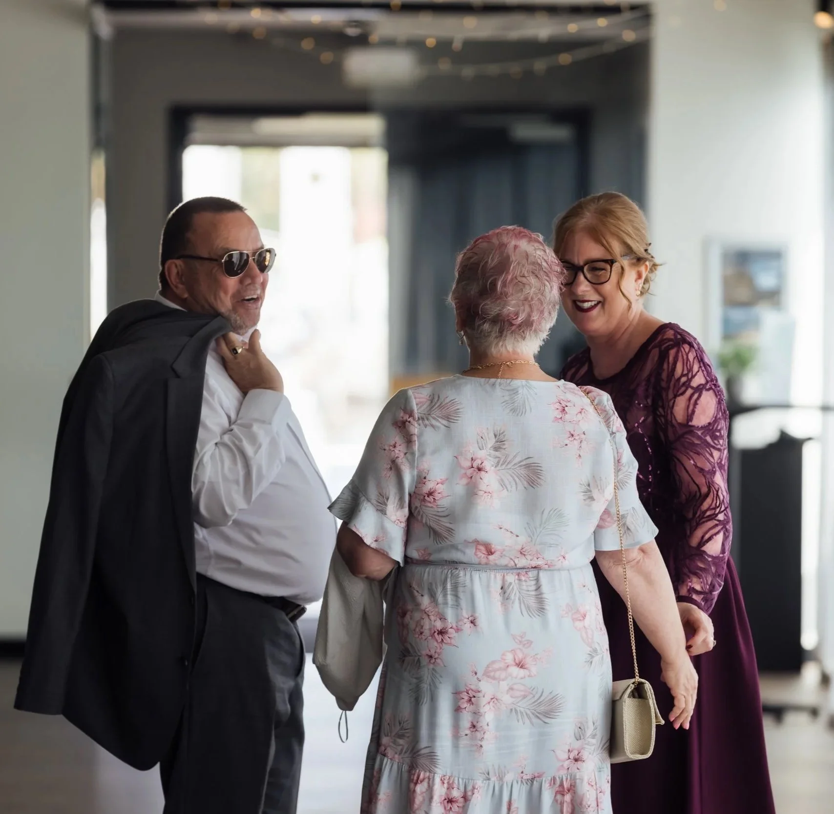 Amanda and a happy couple, smiling indoors.