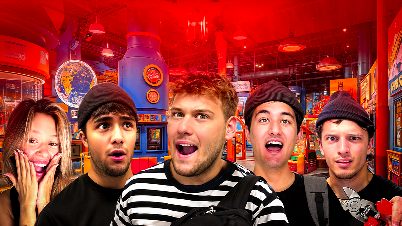 A group of five young people with surprised and excited expressions in an arcade or amusement center with bright red lighting and various game machines in the background.