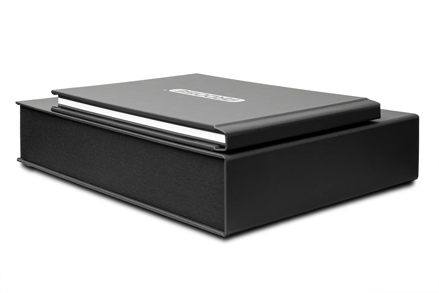 A black box with a textured surface and a closed gray notebook with a logo on top.