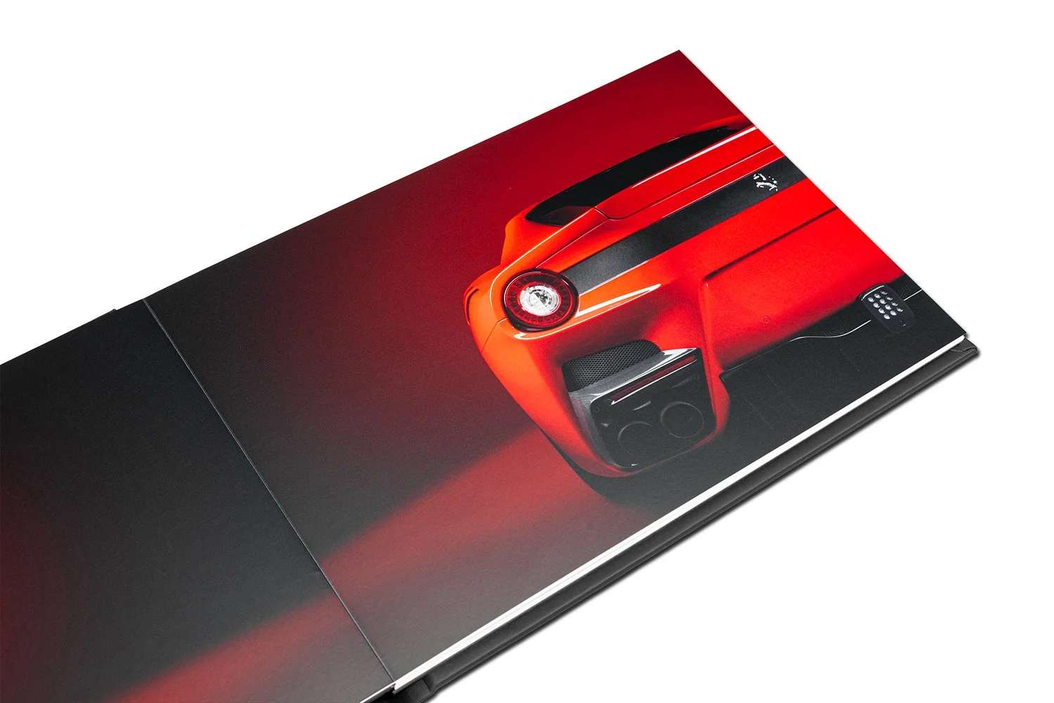 Close-up of a red luxury sports car, showcasing its rear end with round tail light, black details, and dual exhaust pipes.