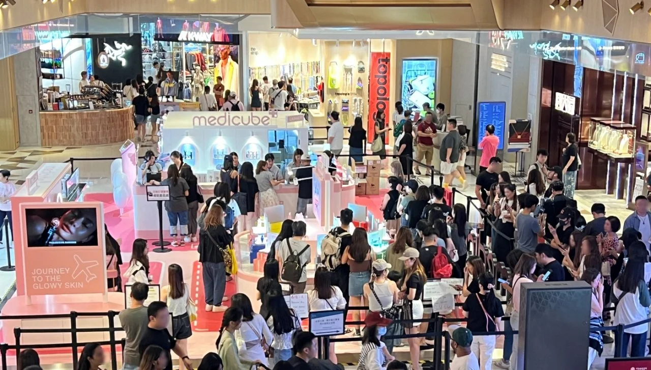 Crowd of people shopping and participating in a skincare or beauty event at a shopping mall.