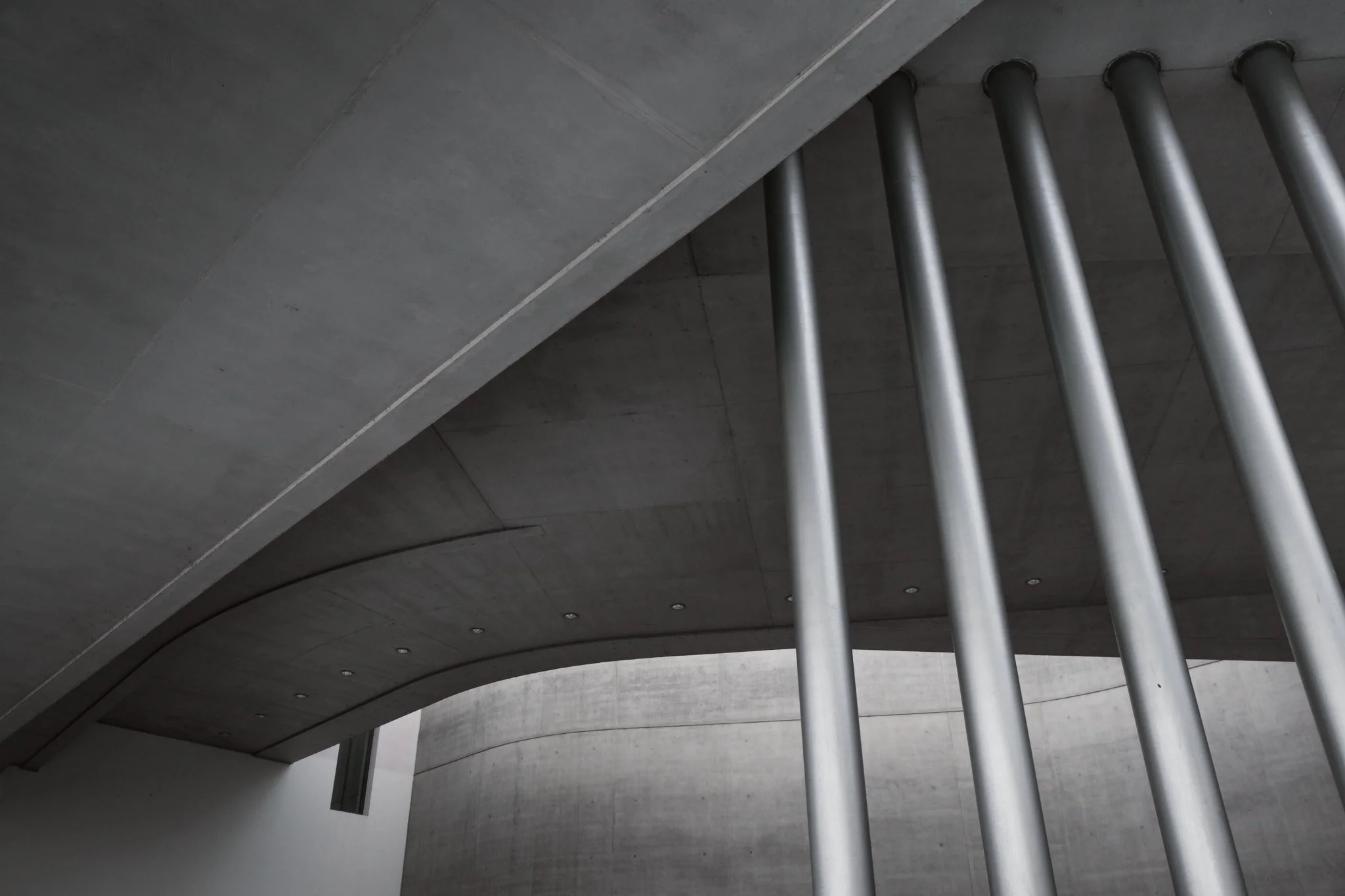 Black and white photograph of the vertical structural fins at MAXXI Rome, read as flat graphic form against the sky.