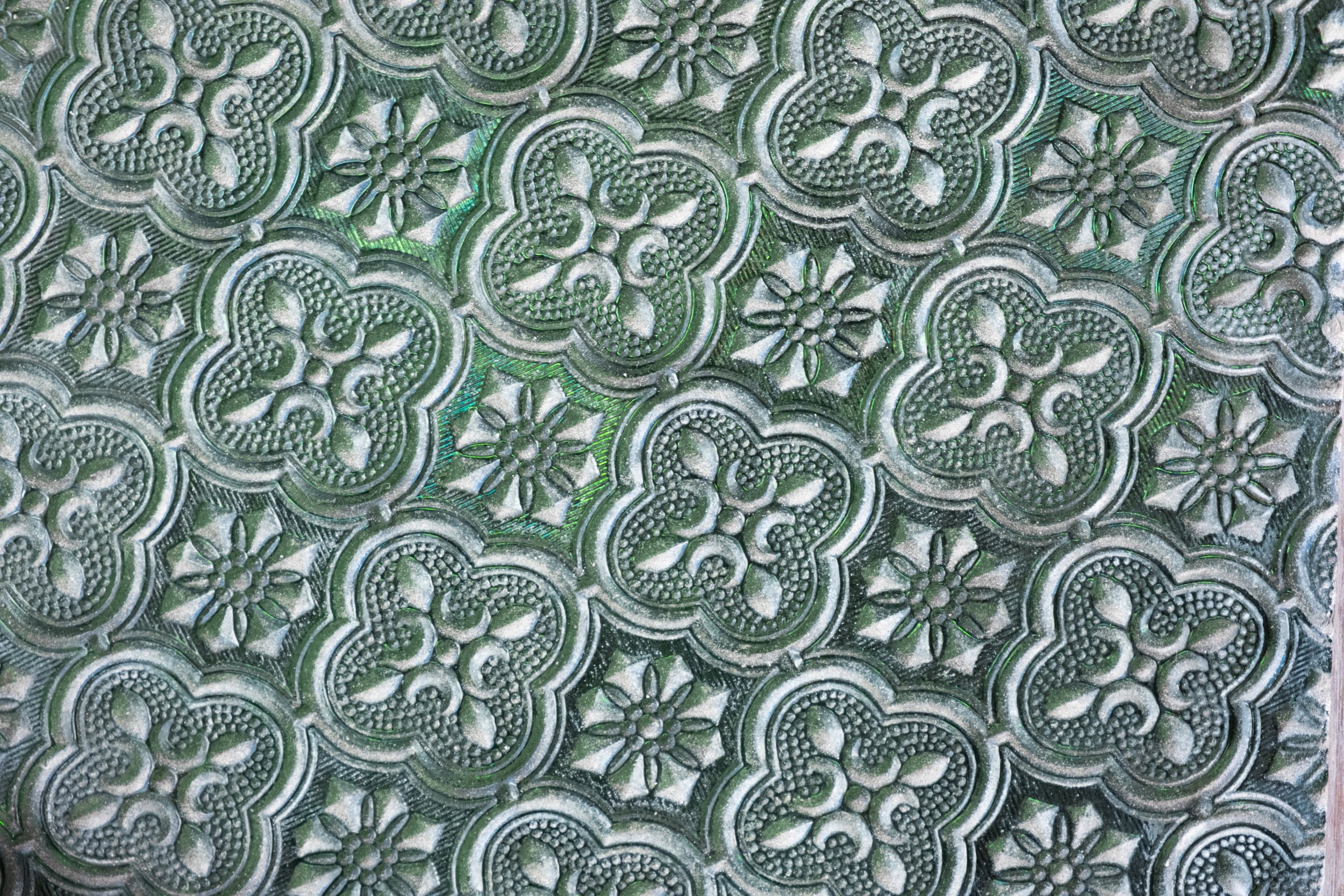 Close-up of decorative patterned glass inside the heritage palace at the National Museum of Qatar in Doha, showing traditional geometric motifs and craftsmanship details.