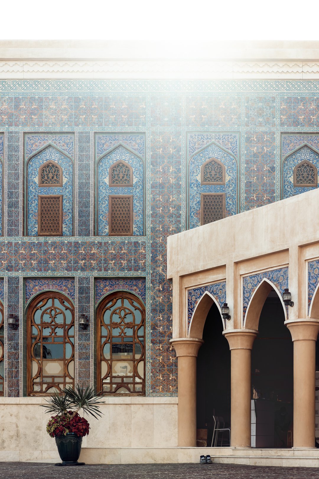 Katara Mosque facade showing window arches and sunlight highlights.
