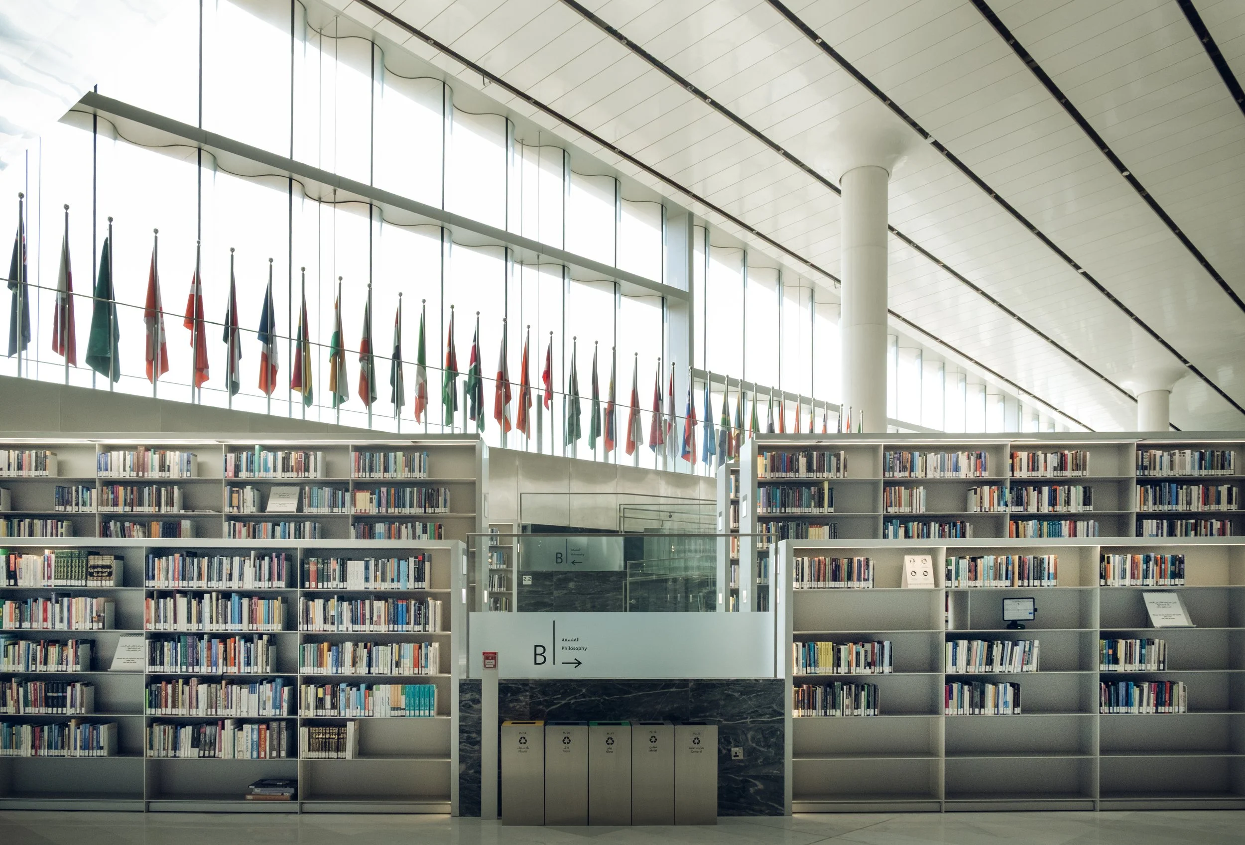 qatar-national-library-interior-bookshelves-flags-natural-light-doha