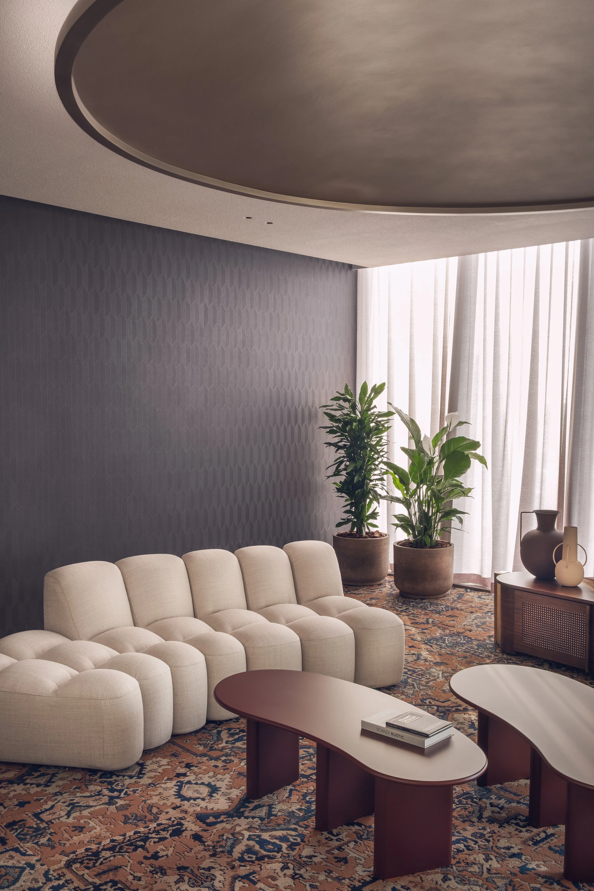 Office lounge area at White & Case Doha featuring sculptural seating, curved ceiling and warm lighting photographed for workplace interior design documentation