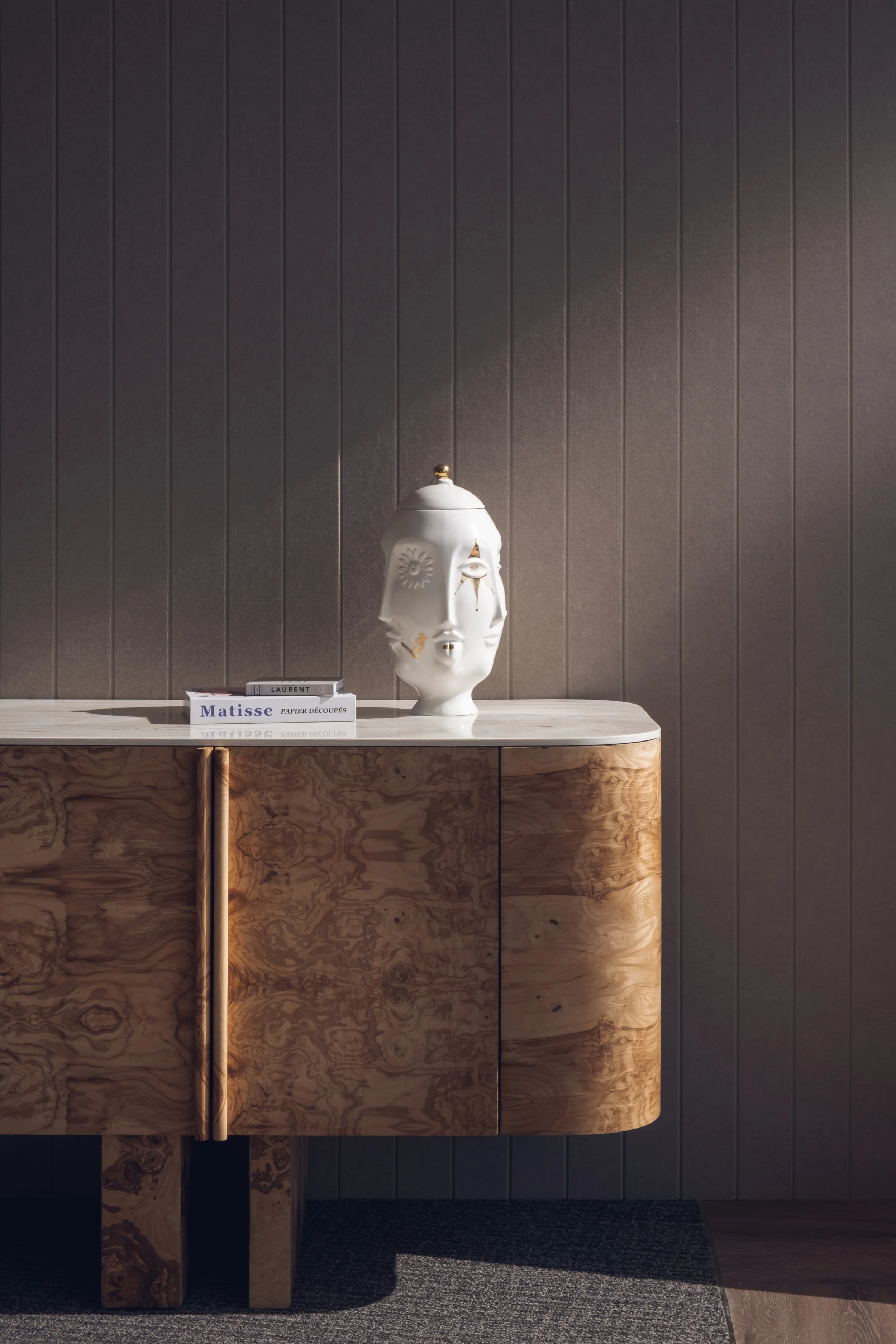 Interior design detail at the White and Case office in Tornado Tower Doha featuring burl wood console, marble top and sculptural ceramic object photographed by architectural photographer Pedro Ferr