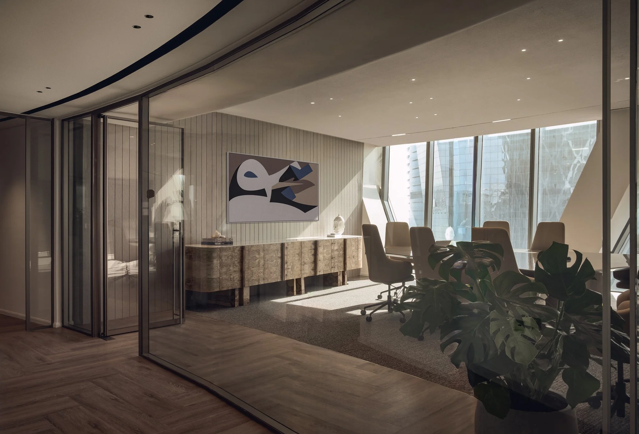 Interior photography of White & Case law firm office in Doha, Qatar. Conference room with curved ceiling, integrated lighting, marble table, and stone wall panels. Project by Roar Interior Design.