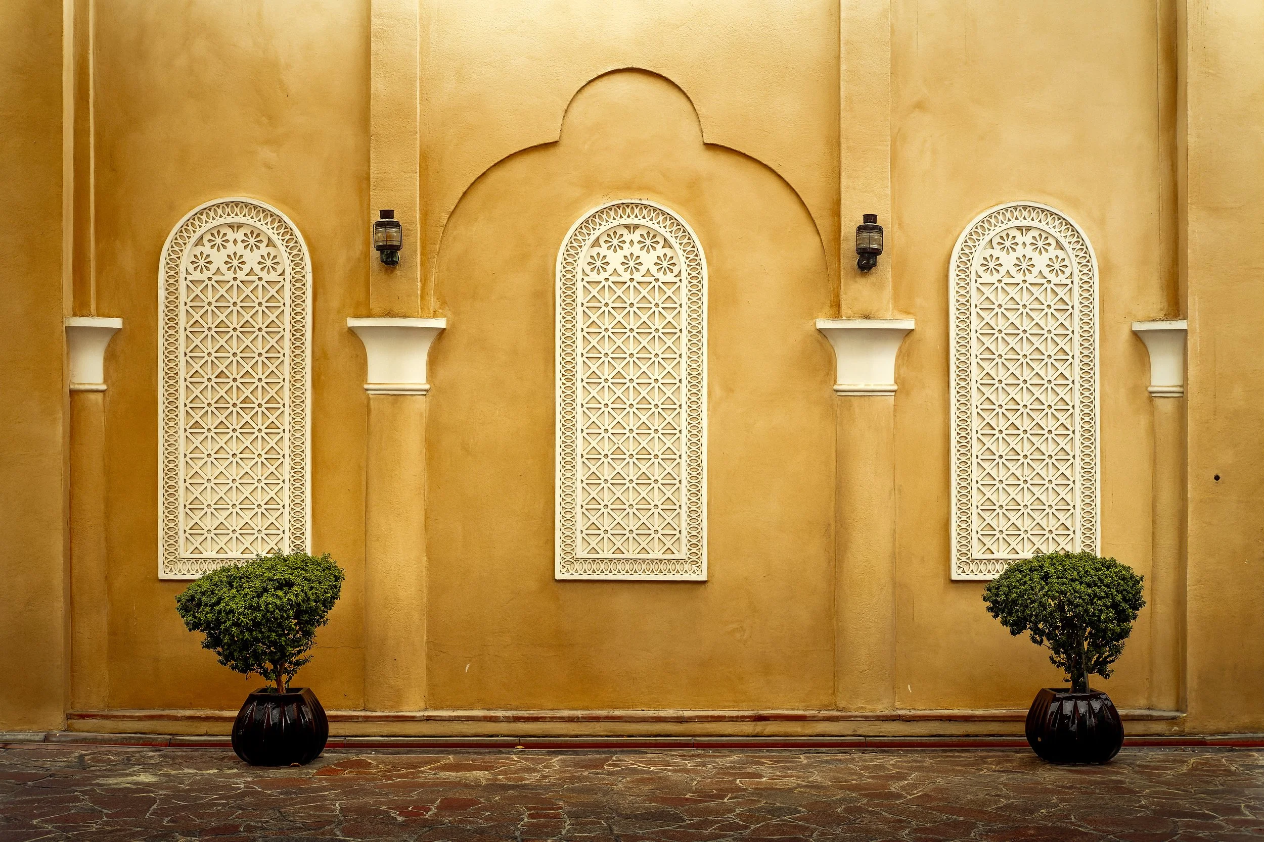 Katara Village façade with ornate white arches and warm plaster — architectural detail in Doha