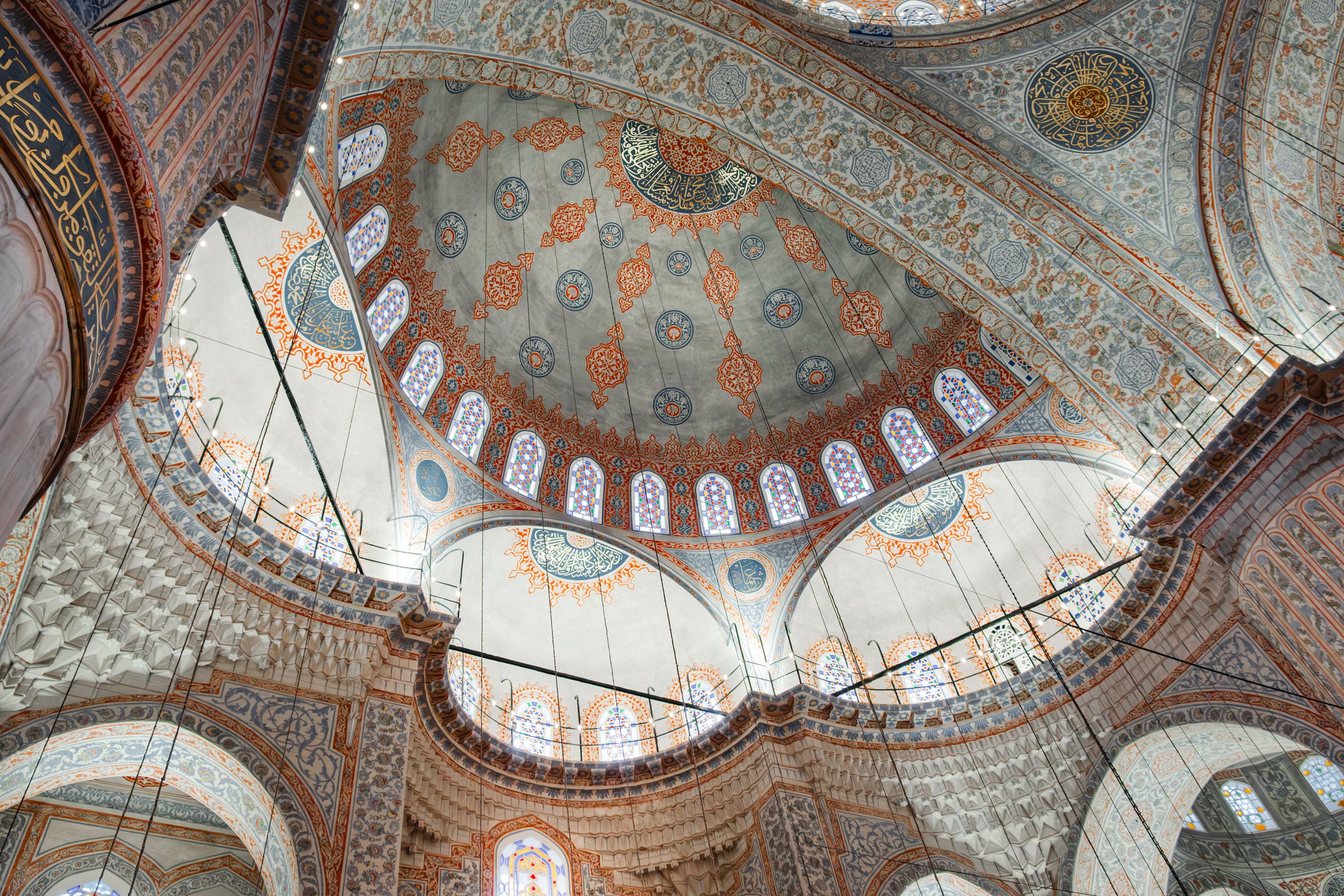 Overhead dome view showing radial design and painted patterns in the Blue Mosque in Istanbul.