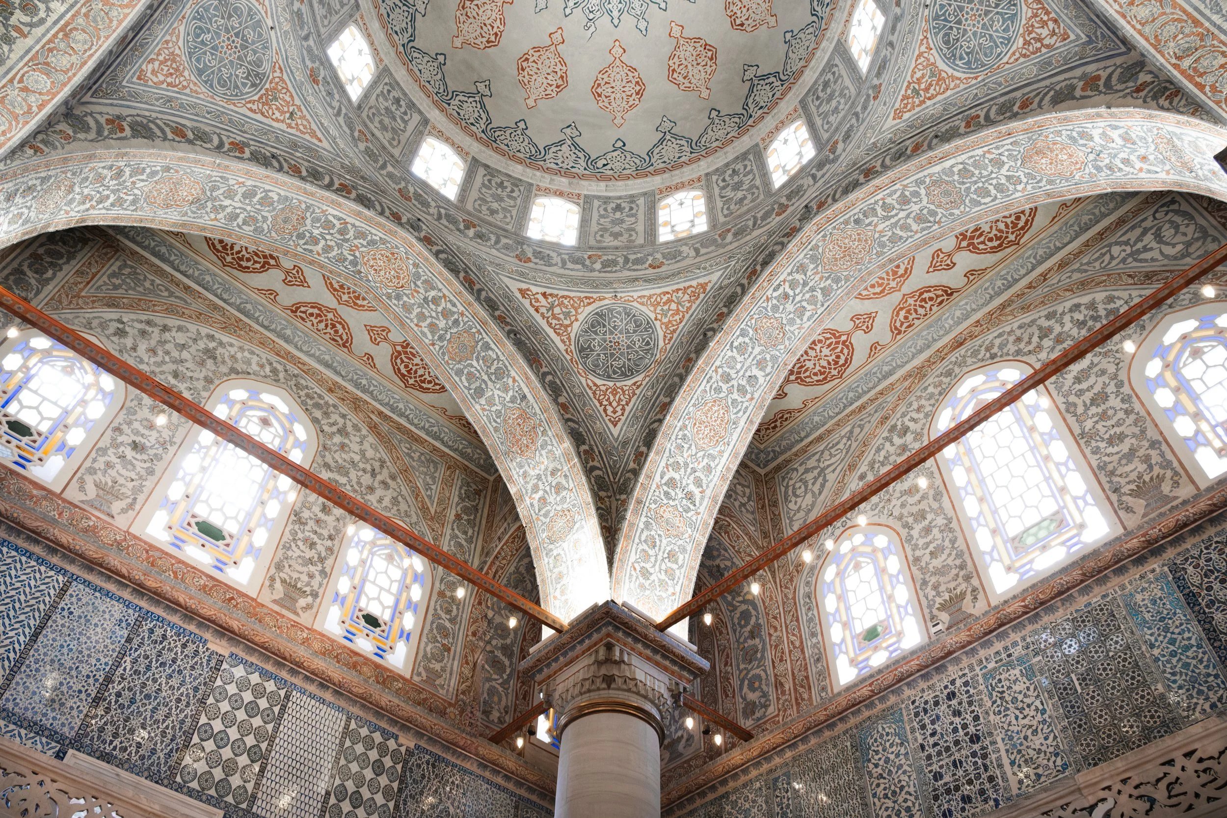 Painted dome arches with calligraphy and patterns inside the Blue Mosque in Istanbul.