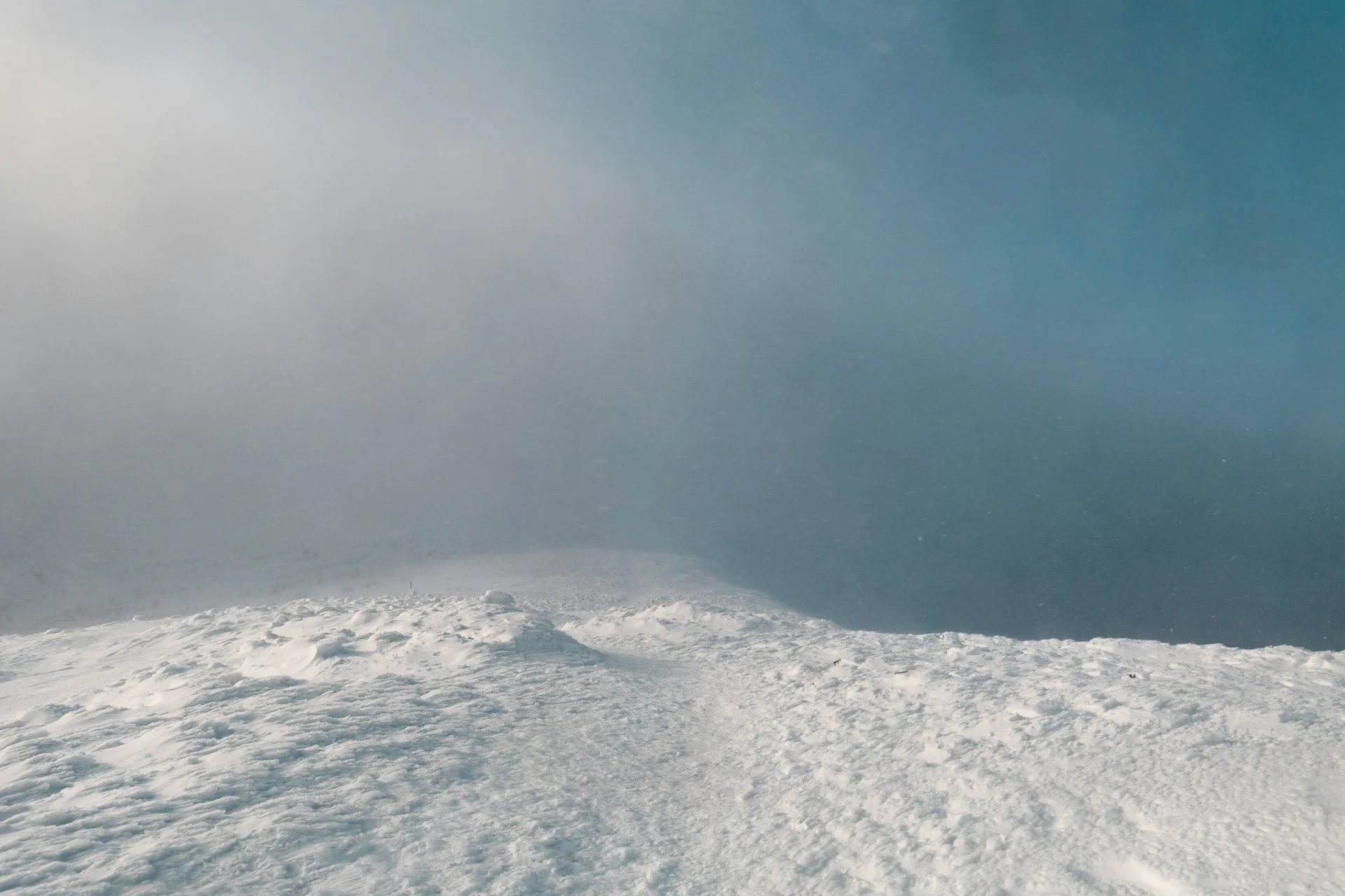 Schneehügel, blauer Himmer es schneit, Berge
