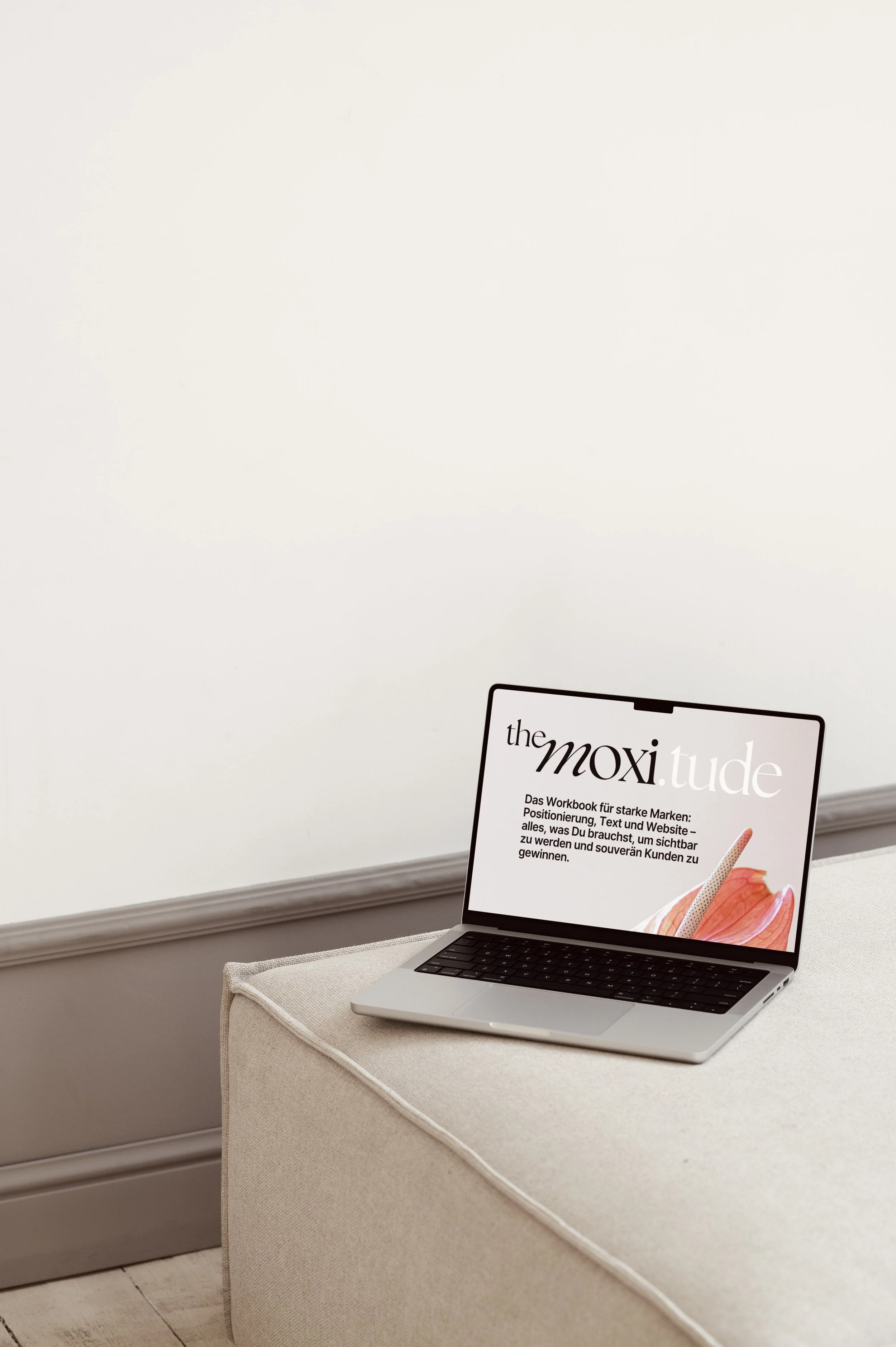 Laptop mit Cover von moxitude steht auf Sofa vor beiger Wand