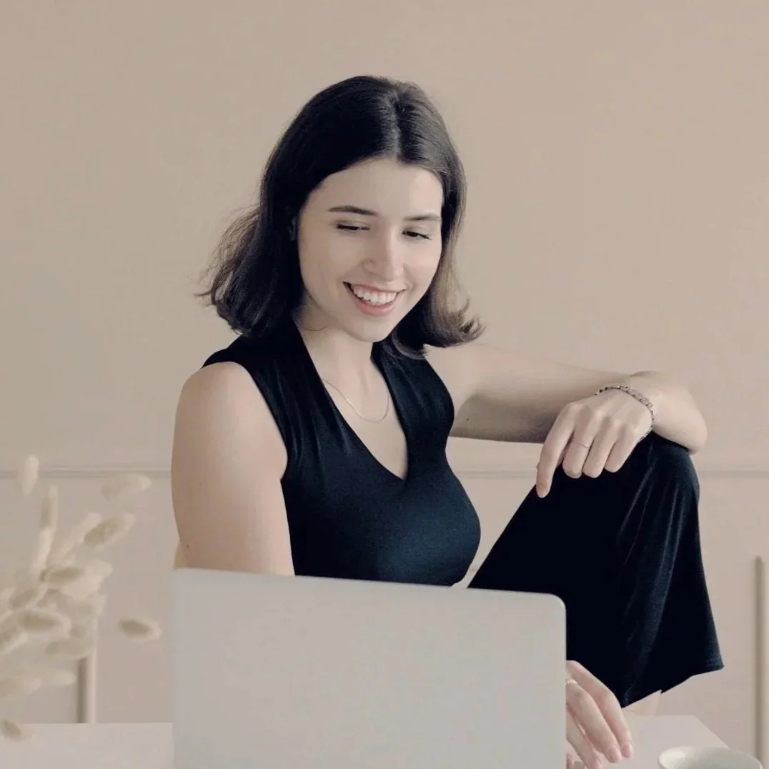 Junge Frau vor Laptop in schwarzem Oberteil