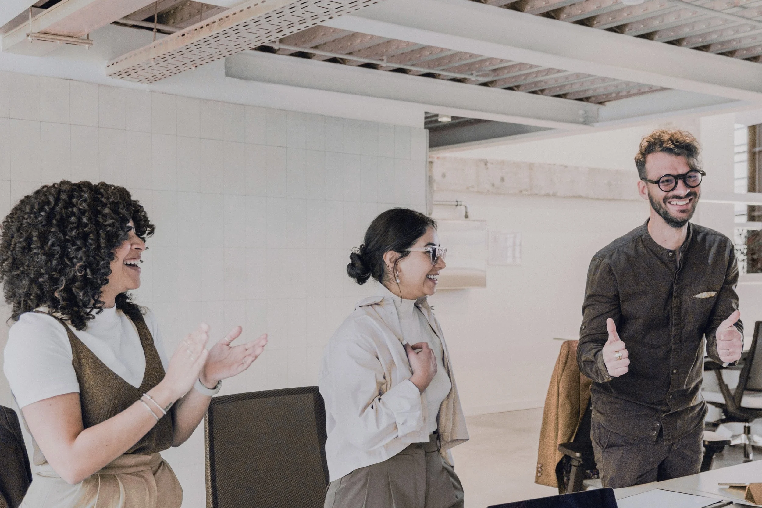 Zwei Frauen, ein Mann lachen, kreative Leute