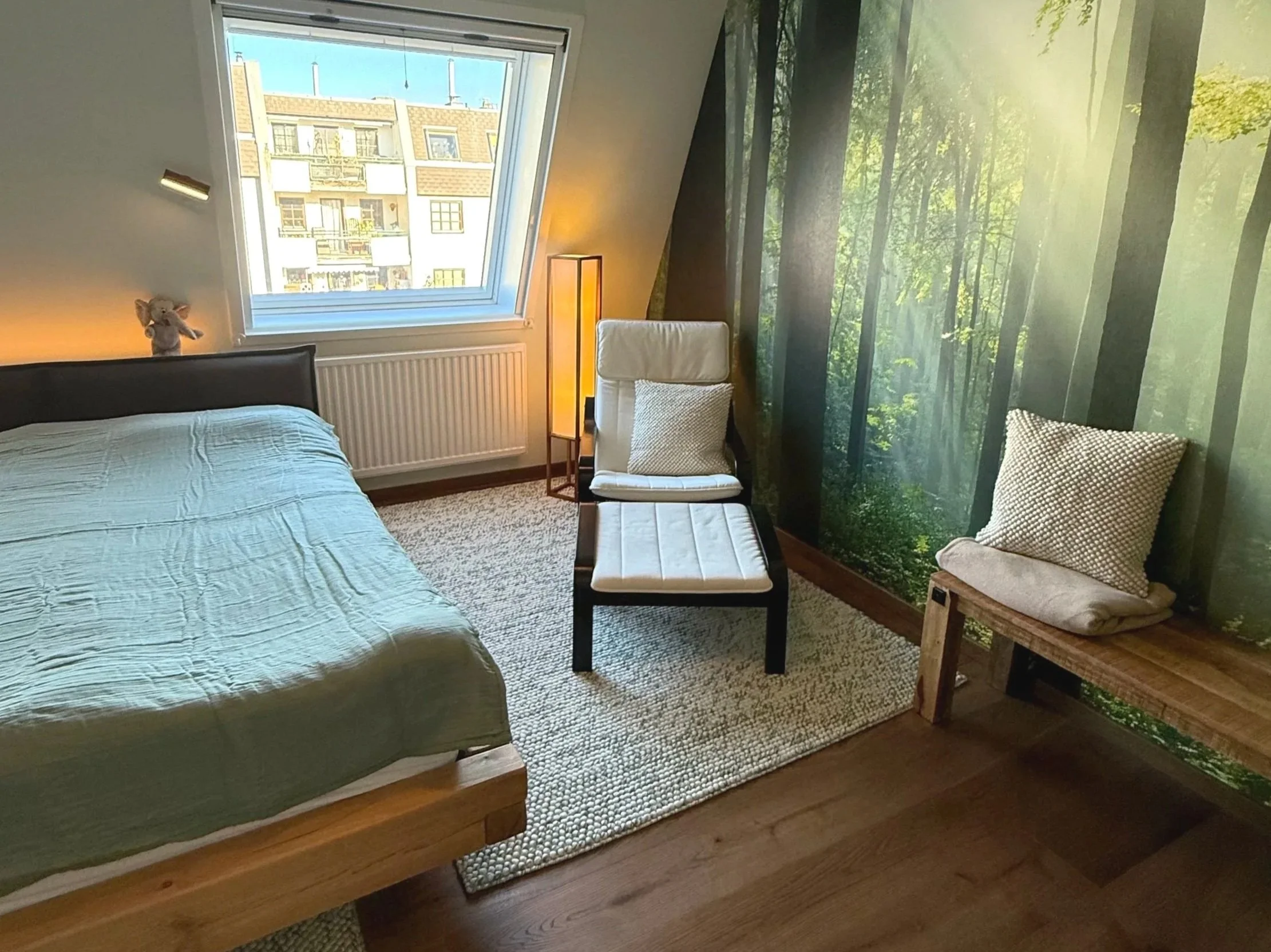 Schlafzimmer nach der Renovierung im beruhigenden Grüntönen, dezent aber durchgängig. Ein gemütlicher Stuhl neben dem Bett erhöht den Gemütlichkeitsfaktor