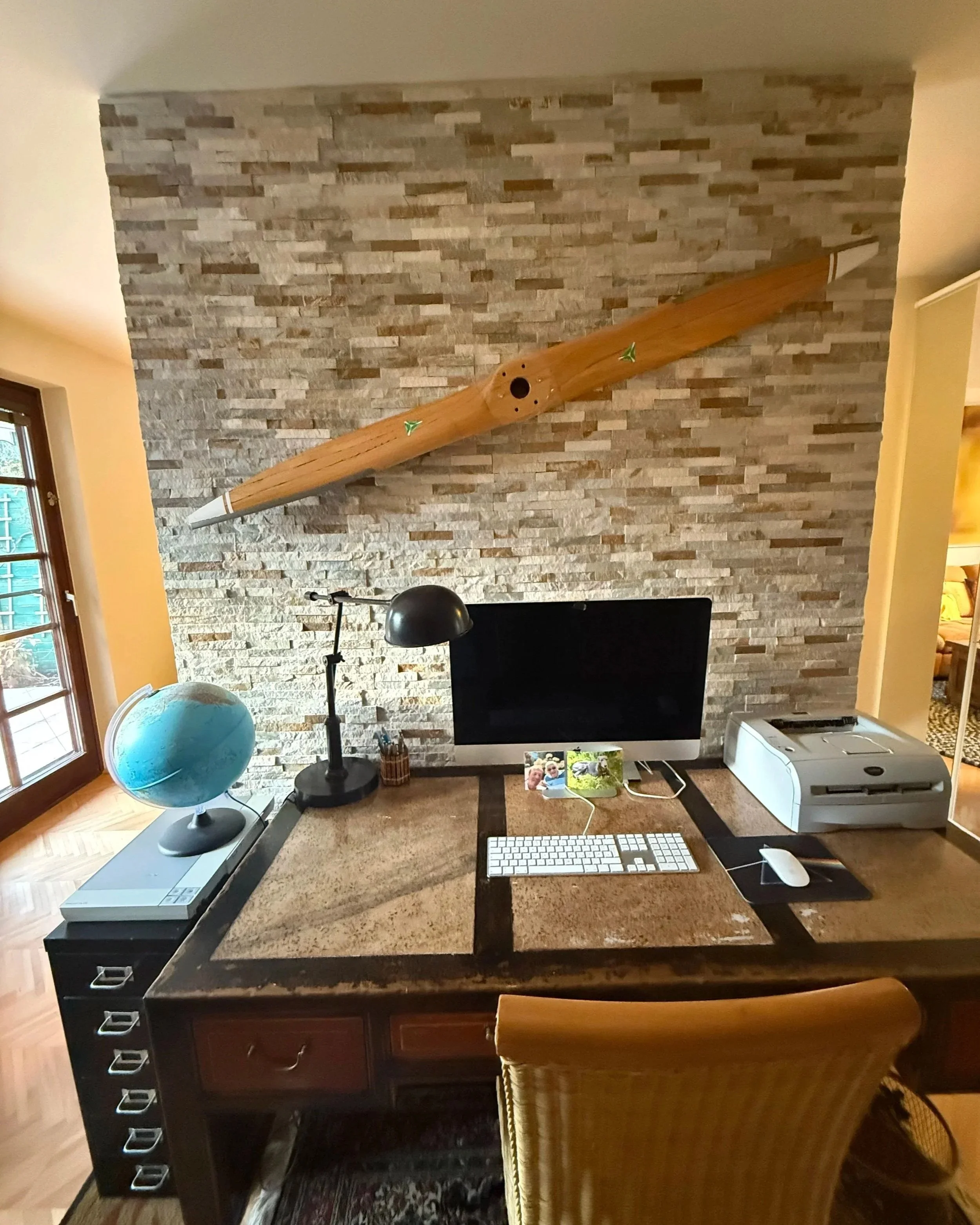 Neu integrierter Arbeitsbereich mit Natursteinwand und großzügigem Schreibtisch