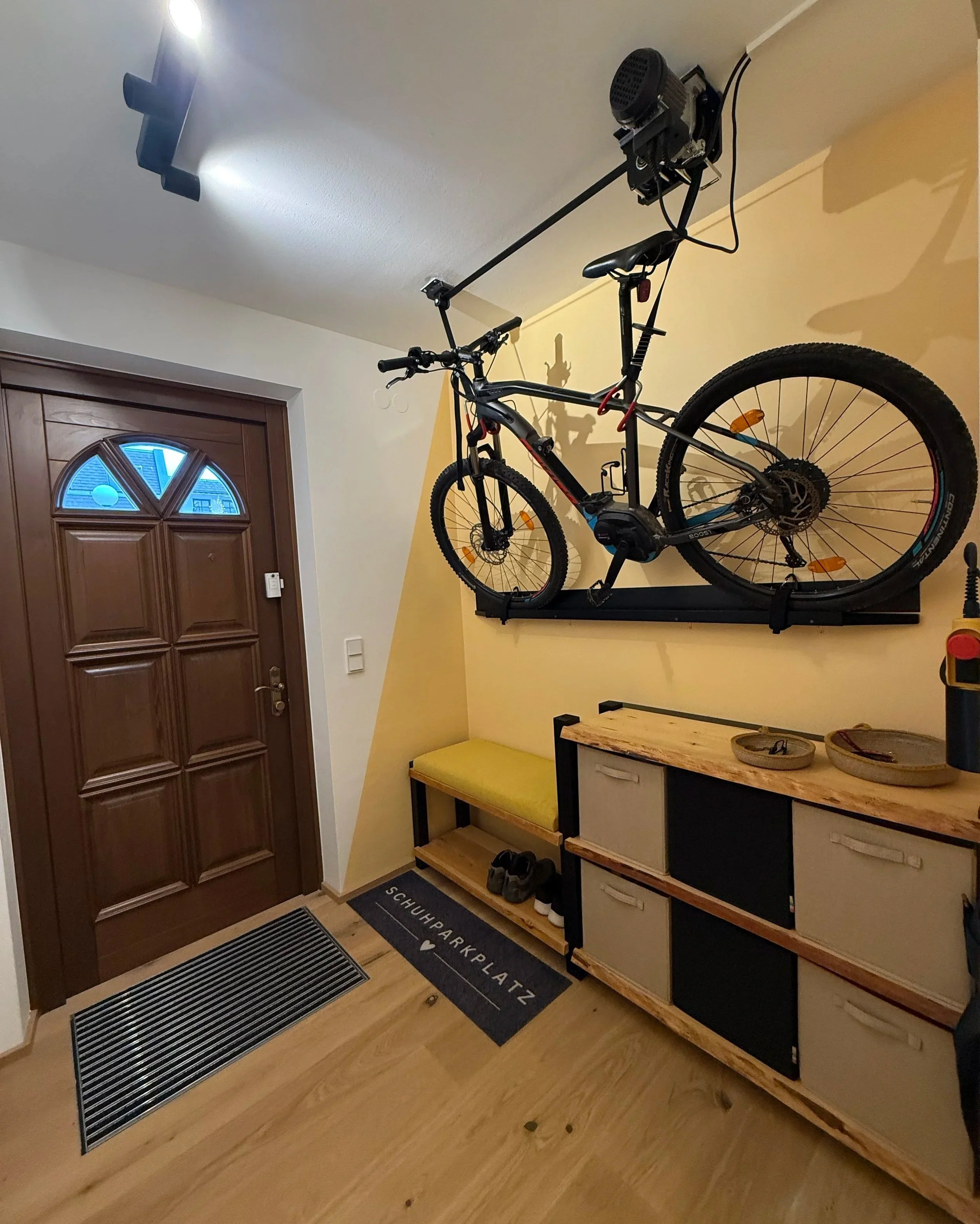 Besonderes Highlight im Windfang ist die Verstauungsmöglichkeit für das E-Bike. Eine elektrische Seilwinde und Brett samt Gurten an der Wand - so steht nach der Radtour nichts im Weg.