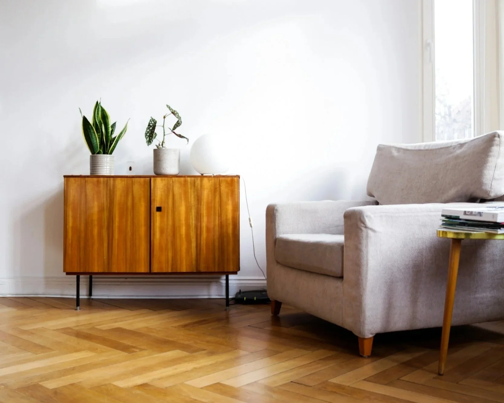 Sessel am Fenster mit Sideboard, Lichtspiel, heller Raum und Pflanzen