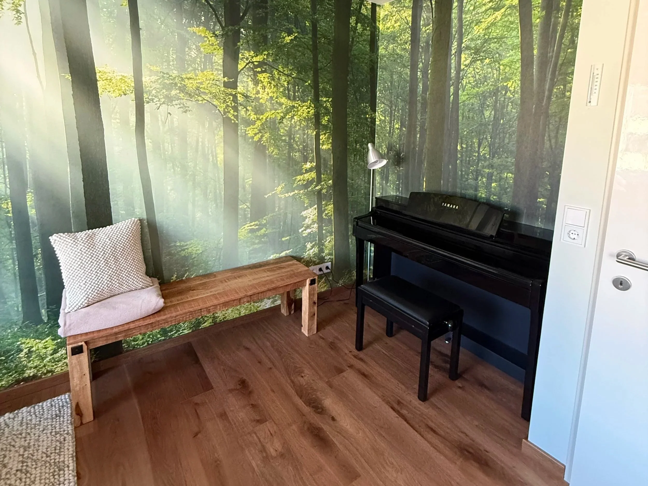 Auch das Piano hat in der Nische seinen Platz gefunden und gibt dem Raum einen dunklen, beruhigend Kontrast danke Farbe und Melodie.