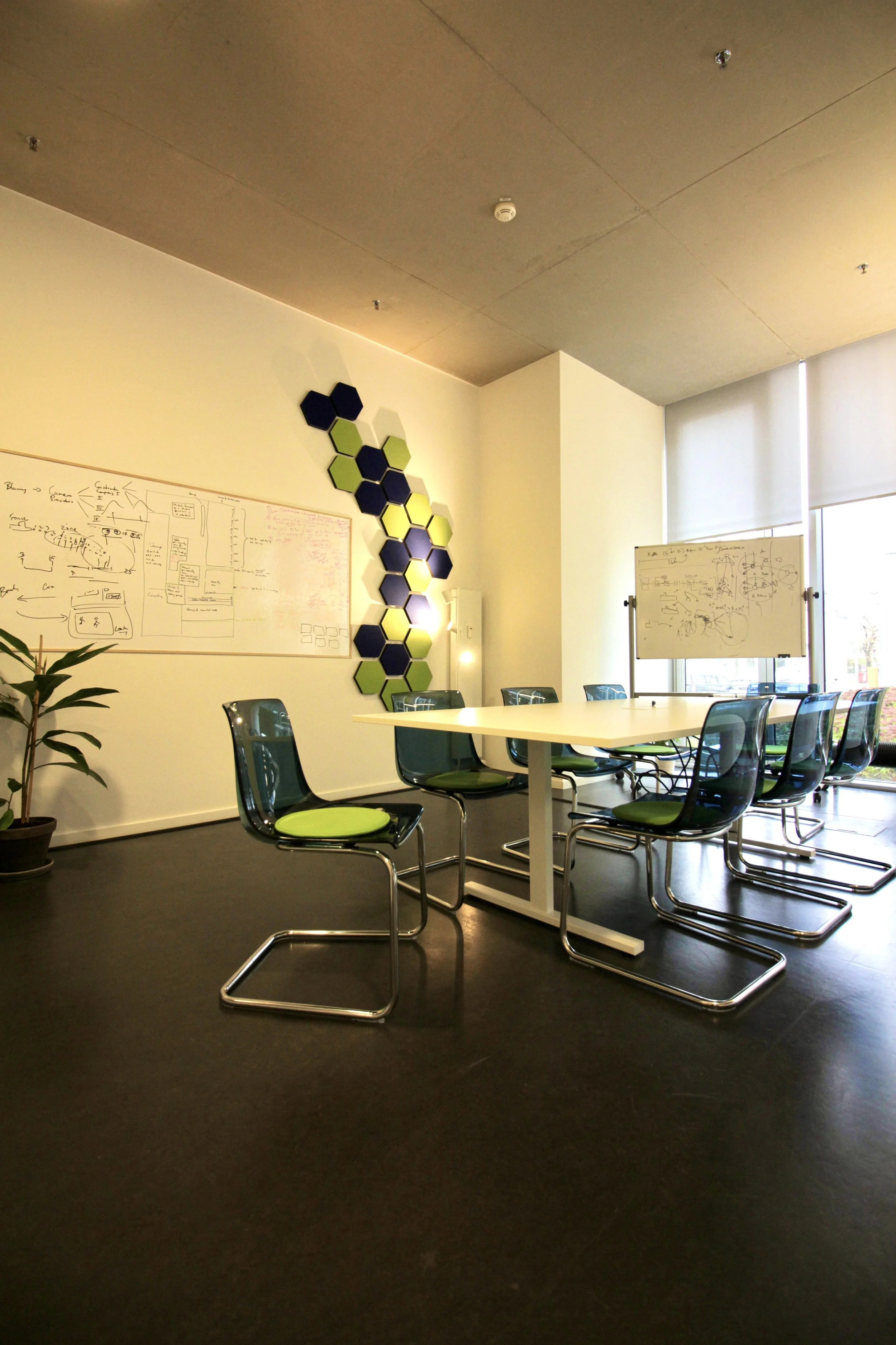 Conxai Technologies Meetingbereich blurred; Farben in grün und blau; Betonwände