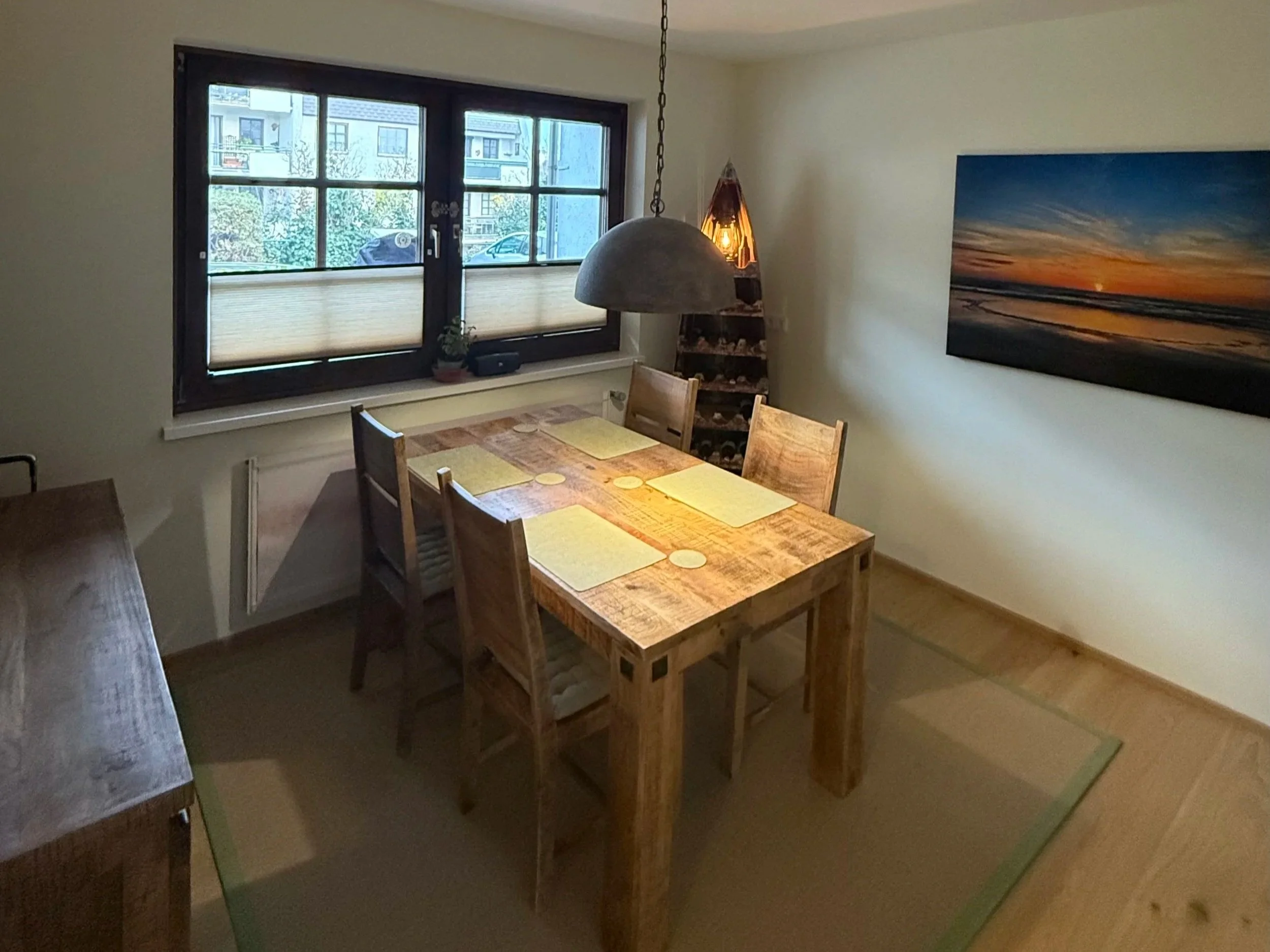 Essbereich nach der Renovierung, Cremefarbene Wände, Holzmöbel in warmen Tönen und Sisalteppich in Mintfarbener Einfassung; Indirekte Beleuchtung und Regal in Bootsform