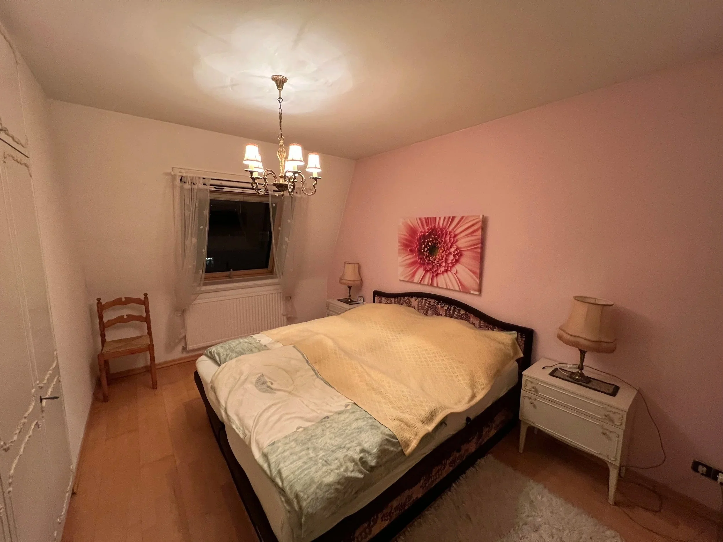 Schlafzimmer vor der Renovierung, klein, schmal und mit rosa Wänden und Einbauschränken auf zwei Seiten